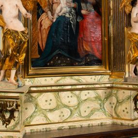 Zdjęcie nr 1: Ołtarz architektoniczny, jednoosiowy, jednokondygnacyjny, ze zwieńczeniem. Ołtarz prostopadłościenny z drewnianą, współczesną mensą i współczesnym antependium z przedstawieniem świętej w otoczeniu wieńca z kwiatami. Nastawa ujęta ukośnie dostawionymi filarami kanelowanymi, ustawionymi na postumentach z konsolami o prostych kapitelach utworzonych z roccailli i konsol podtrzymujących przerwane belkowanie zwieńczone ćwierćkolistymi naczółkami. Zwieńczenie o wklęsłych bokach zakończone profilowanym gzymsem w kształcie łuku nadwieszonego półkolistego. Na tle filaru, na konsolach ustawione figury uskrzydlonych aniołów. W polu środkowym obraz w kształcie stojącego prostokąta zamkniętego łukiem nadwieszonym półkolistym ozdobiony rocaillem. W ramie obraz z przedstawieniem św. Anny Samotrzeciej z Madonną z Dzieciątkiem. Nad ramą baldachim z lambrekinem. W zwieńczeniu serce Gorejące na tle glorii promienistej z chmurkami, zwieńczonej uskrzydloną główką anielską; nad gzymsem zwieńczenia  grzebień utworzony z ażurowego rocaillu. 