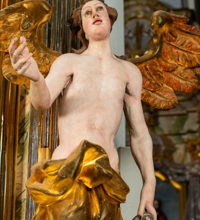 Zdjęcie nr 8: Ołtarz architektoniczny, jednoosiowy, jednokondygnacyjny, ze zwieńczeniem. Ołtarz prostopadłościenny z drewnianą, współczesną mensą i współczesnym antependium z przedstawieniem świętej w otoczeniu wieńca z kwiatami. Nastawa ujęta ukośnie dostawionymi filarami kanelowanymi, ustawionymi na postumentach z konsolami o prostych kapitelach utworzonych z roccailli i konsol podtrzymujących przerwane belkowanie zwieńczone ćwierćkolistymi naczółkami. Zwieńczenie o wklęsłych bokach zakończone profilowanym gzymsem w kształcie łuku nadwieszonego półkolistego. Na tle filaru, na konsolach ustawione figury uskrzydlonych aniołów. W polu środkowym obraz w kształcie stojącego prostokąta zamkniętego łukiem nadwieszonym półkolistym ozdobiony rocaillem. W ramie obraz z przedstawieniem św. Anny Samotrzeciej z Madonną z Dzieciątkiem. Nad ramą baldachim z lambrekinem. W zwieńczeniu serce Gorejące na tle glorii promienistej z chmurkami, zwieńczonej uskrzydloną główką anielską; nad gzymsem zwieńczenia  grzebień utworzony z ażurowego rocaillu. 