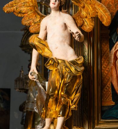 Zdjęcie nr 15: Ołtarz architektoniczny, jednoosiowy, jednokondygnacyjny, ze zwieńczeniem. Ołtarz prostopadłościenny z drewnianą, współczesną mensą i współczesnym antependium z przedstawieniem świętej w otoczeniu wieńca z kwiatami. Nastawa ujęta ukośnie dostawionymi filarami kanelowanymi, ustawionymi na postumentach z konsolami o prostych kapitelach utworzonych z roccailli i konsol podtrzymujących przerwane belkowanie zwieńczone ćwierćkolistymi naczółkami. Zwieńczenie o wklęsłych bokach zakończone profilowanym gzymsem w kształcie łuku nadwieszonego półkolistego. Na tle filaru, na konsolach ustawione figury uskrzydlonych aniołów. W polu środkowym obraz w kształcie stojącego prostokąta zamkniętego łukiem nadwieszonym półkolistym ozdobiony rocaillem. W ramie obraz z przedstawieniem św. Anny Samotrzeciej z Madonną z Dzieciątkiem. Nad ramą baldachim z lambrekinem. W zwieńczeniu serce Gorejące na tle glorii promienistej z chmurkami, zwieńczonej uskrzydloną główką anielską; nad gzymsem zwieńczenia  grzebień utworzony z ażurowego rocaillu. 