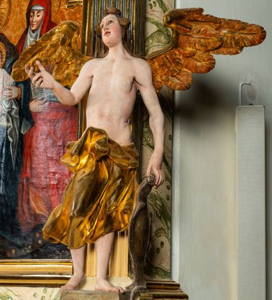 Zdjęcie nr 18: Ołtarz architektoniczny, jednoosiowy, jednokondygnacyjny, ze zwieńczeniem. Ołtarz prostopadłościenny z drewnianą, współczesną mensą i współczesnym antependium z przedstawieniem świętej w otoczeniu wieńca z kwiatami. Nastawa ujęta ukośnie dostawionymi filarami kanelowanymi, ustawionymi na postumentach z konsolami o prostych kapitelach utworzonych z roccailli i konsol podtrzymujących przerwane belkowanie zwieńczone ćwierćkolistymi naczółkami. Zwieńczenie o wklęsłych bokach zakończone profilowanym gzymsem w kształcie łuku nadwieszonego półkolistego. Na tle filaru, na konsolach ustawione figury uskrzydlonych aniołów. W polu środkowym obraz w kształcie stojącego prostokąta zamkniętego łukiem nadwieszonym półkolistym ozdobiony rocaillem. W ramie obraz z przedstawieniem św. Anny Samotrzeciej z Madonną z Dzieciątkiem. Nad ramą baldachim z lambrekinem. W zwieńczeniu serce Gorejące na tle glorii promienistej z chmurkami, zwieńczonej uskrzydloną główką anielską; nad gzymsem zwieńczenia  grzebień utworzony z ażurowego rocaillu. 