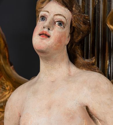 Zdjęcie nr 23: Ołtarz architektoniczny, jednoosiowy, jednokondygnacyjny, ze zwieńczeniem. Ołtarz prostopadłościenny z drewnianą, współczesną mensą i współczesnym antependium z przedstawieniem świętej w otoczeniu wieńca z kwiatami. Nastawa ujęta ukośnie dostawionymi filarami kanelowanymi, ustawionymi na postumentach z konsolami o prostych kapitelach utworzonych z roccailli i konsol podtrzymujących przerwane belkowanie zwieńczone ćwierćkolistymi naczółkami. Zwieńczenie o wklęsłych bokach zakończone profilowanym gzymsem w kształcie łuku nadwieszonego półkolistego. Na tle filaru, na konsolach ustawione figury uskrzydlonych aniołów. W polu środkowym obraz w kształcie stojącego prostokąta zamkniętego łukiem nadwieszonym półkolistym ozdobiony rocaillem. W ramie obraz z przedstawieniem św. Anny Samotrzeciej z Madonną z Dzieciątkiem. Nad ramą baldachim z lambrekinem. W zwieńczeniu serce Gorejące na tle glorii promienistej z chmurkami, zwieńczonej uskrzydloną główką anielską; nad gzymsem zwieńczenia  grzebień utworzony z ażurowego rocaillu. 