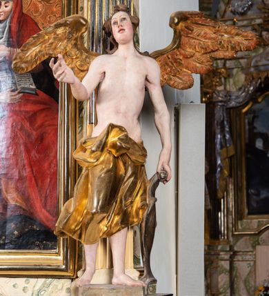 Zdjęcie nr 7: Ołtarz architektoniczny, jednoosiowy, jednokondygnacyjny, ze zwieńczeniem. Ołtarz prostopadłościenny z drewnianą, współczesną mensą i współczesnym antependium z przedstawieniem świętej w otoczeniu wieńca z kwiatami. Nastawa ujęta ukośnie dostawionymi filarami kanelowanymi, ustawionymi na postumentach z konsolami o prostych kapitelach utworzonych z roccailli i konsol podtrzymujących przerwane belkowanie zwieńczone ćwierćkolistymi naczółkami. Zwieńczenie o wklęsłych bokach zakończone profilowanym gzymsem w kształcie łuku nadwieszonego półkolistego. Na tle filaru, na konsolach ustawione figury uskrzydlonych aniołów. W polu środkowym obraz w kształcie stojącego prostokąta zamkniętego łukiem nadwieszonym półkolistym ozdobiony rocaillem. W ramie obraz z przedstawieniem św. Anny Samotrzeciej z Madonną z Dzieciątkiem. Nad ramą baldachim z lambrekinem. W zwieńczeniu serce Gorejące na tle glorii promienistej z chmurkami, zwieńczonej uskrzydloną główką anielską; nad gzymsem zwieńczenia  grzebień utworzony z ażurowego rocaillu. 