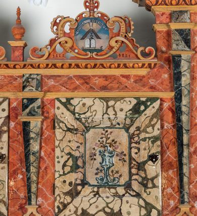 Zdjęcie nr 100: Umeblowanie zakrystii usytuowane jest wzdłuż ścian północnej, południowej i wschodniej pomieszczenia.  Na ścianie północnej, w części dolnej znajdują się trzy połączone ze sobą komody, każda o czterech szufladach, nakryte jednym blatem. W części górnej mieszczą się pięcioosiowe szafki z szufladami w cokole. Osie artykułowe są pilastrami hermowymi. Na osi środkowej szafka jest nieco wyższa i szersza z drzwiczkami dekorowanymi prostokątną, uszatą, oprofilowaną płyciną z malowanym przedstawieniem Chrystusa Eucharystycznego. Drzwiczki pozostałych szafek mają kształt stojących prostokątów i dekorowane są płycinami o wklęsłych narożach, zdobionymi gałązkami czerwonych róż, ułożonych w rokokowych wazonach. Ścianki zamknięte są niepełnym belkowaniem z gzymsem. W partii zwieńczenia osie artykułowane są cokolikami, na których ustawione są toczone, kuliste wazoniki. Pomiędzy nimi umieszczone są kartusze utworzone z ornamentu małżowinowo-chrząstkowego z malowanymi emblematami na owalnych medalionach, które ułożone są kolejno od lewej strony: 
1. Pionowo ustawiony miecz, ostrzem skierowany ku górze, połączony ze skrzyżowanymi berłem i dwoma kluczami, od których odchodzą fantazyjnie ułożone sznury w kolorze czerwonym. U góry napis na szarfie: „OBEDITE”.
2. W górnej części wyłaniająca się z chmur ręka trzymająca w dłoni węgielnicę i przymocowane do niej na łańcuszku tablice Dekalogu. Napis na szarfie: „OMNIA SVSTINET”.
3. Bóg Ojciec ukazany w półpostaci, lewą ręką opiera się na kuli ziemskiej, prawą czyni gest błogosławieństwa. 
4. Bujnie ulistnione, ciemnozielone drzewko spięte w dolnej części złotą formą w kształcie dwóch wywiniętych wolutek. Napis na szarfie: „GAVDET PATIENTIA DVRIS”. 
5. W górnej części obrazu z chmur wyłania się ręka, która zrzuca na ziemię iskrzący pocisk i dwa skrzyżowane pioruny, połączone parą białych skrzydeł. Napis „FORTIS VLTOR”.
 
Na ścianie środkowej, wschodniej znajduje się sarkofagowa mensa, powyżej parawanowa ścianka na profilowanym cokole, artykułowana pilastrami, pomiędzy którymi umieszczone są płyciny z kształcie leżących prostokątów z obrazami; ścianka zamknięta jest profilowanym gzymsem. W zwieńczeniu, na jej skrajach znajdują się owalne medaliony ujęte w kartusze z ornamentu małżowinowo-chrząstkowego. W medalionie po lewej stronie namalowane są litery alfa i omega na błękitnym tle oraz wstęga z napisem: „RENOVATUM A(NNO) D(OMINI) 1975”. Po prawej stronie analogiczny kartusz z literami w medalionie: „Ω / O / N” wpisane w formę krzyża, otoczonego niepełną aureolą; powyżej wstęga z napisem: „VIDENTEM AUDERE”. W płycinach obrazy przedstawiają świętych w ujęciu do pasa, zwróconych ku środkowi; od lewej:
1. Święty Demetriusz z włócznią opartą o prawy bark, ubrany w habit zakonu kanoników laterańskich od pokuty.
2. Święty Klet z aniołkiem, który trzyma w dłoni palmę męczeństwa i krzyż papieski. W prawym górnym narożu obrazu napis: „FAC HVIC SIGNO HONOREM”.
3. Święty Augustyn z gorejącym sercem na piersi i aniołkiem z łyżką i miseczką w dłoniach.
4. Święty ubrany w habit Marków, który trzyma w dłoni serce z krzyżem, podtrzymywane przez Chrystusa na obłokach – prawdopodobnie św. Cyriak, założyciel zakonu.
 
Na ścianie południowej znajduje się analogiczne umeblowanie, jak na ścianie północnej. W dolnej części dwie komody, a w miejscu trzeciej od wschodu szafka zdobiona dwiema uszatymi płycinami. Górna część mebla w przeciwieństwie do ściany północnej bez podwyższenia części środkowej. 
Na ścianie południowej:
1. Jasnobrązowa harfa na błękitnym tle i napis: „IN DOMINO”.
2. Ciemnobrązowy ptak i trzy podrywające się do lotu młode, w górnej części złote słońce i napis: „NON QUAE SVPER TERRAM.”
3. Po lewej stronie kompozycji wyłaniająca się z chmur ręka trzymająca skrzyżowane: miecz, czerwony krzyż i palmę. Napis: „NON ERVBESCO”.
4. W centrum przedstawienia krzak białej lilii o trzech rozgałęzieniach, w tle chmury w odcieniach koloru szaroniebieskiego. Napis na szarfie: „PER ARDVA DVLCIS”.
5. W lewej części kompozycji uskrzydlony jeleń, wspięty na tylnych nogach, po prawej stronie czarne i brązowe skały, w partii górnej otwarta korona, umieszczona pośrodku obłoku obwiedzionego biało-czerwonym pasem. Napis: „ET COMPREHENDATIS”.
 
W miejscu połączenia komód ścian północnej i południowej z dolną częścią konstrukcji na ścianie wschodniej znajdują się ukośnie ustawione, jednoskrzydłowe szafki o drzwiczkach dekorowanych prostokątną płyciną o wklęsłych narożach. Ścianki boczne części północnej i południowej zdobione są ukośną kratką. Powierzchnia szafek i komód pokryta jest polichromią imitującą marmur w kolorze beżowym, szarokremowym, różowym i rdzawym. Blaty malowane są farbą olejną w kolorze beżowym. Obramienia medalionów malowane w kolorze rdzawozłotym. Tło w większości medalionów w odcieniach błękitu, w górnych częściach majuskułowe napisy objaśniające przedstawienie, umieszczone w białych i półkoliście ułożonych szarfach. 