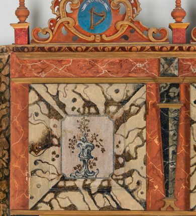 Zdjęcie nr 50: Umeblowanie zakrystii usytuowane jest wzdłuż ścian północnej, południowej i wschodniej pomieszczenia.  Na ścianie północnej, w części dolnej znajdują się trzy połączone ze sobą komody, każda o czterech szufladach, nakryte jednym blatem. W części górnej mieszczą się pięcioosiowe szafki z szufladami w cokole. Osie artykułowe są pilastrami hermowymi. Na osi środkowej szafka jest nieco wyższa i szersza z drzwiczkami dekorowanymi prostokątną, uszatą, oprofilowaną płyciną z malowanym przedstawieniem Chrystusa Eucharystycznego. Drzwiczki pozostałych szafek mają kształt stojących prostokątów i dekorowane są płycinami o wklęsłych narożach, zdobionymi gałązkami czerwonych róż, ułożonych w rokokowych wazonach. Ścianki zamknięte są niepełnym belkowaniem z gzymsem. W partii zwieńczenia osie artykułowane są cokolikami, na których ustawione są toczone, kuliste wazoniki. Pomiędzy nimi umieszczone są kartusze utworzone z ornamentu małżowinowo-chrząstkowego z malowanymi emblematami na owalnych medalionach, które ułożone są kolejno od lewej strony: 
1. Pionowo ustawiony miecz, ostrzem skierowany ku górze, połączony ze skrzyżowanymi berłem i dwoma kluczami, od których odchodzą fantazyjnie ułożone sznury w kolorze czerwonym. U góry napis na szarfie: „OBEDITE”.
2. W górnej części wyłaniająca się z chmur ręka trzymająca w dłoni węgielnicę i przymocowane do niej na łańcuszku tablice Dekalogu. Napis na szarfie: „OMNIA SVSTINET”.
3. Bóg Ojciec ukazany w półpostaci, lewą ręką opiera się na kuli ziemskiej, prawą czyni gest błogosławieństwa. 
4. Bujnie ulistnione, ciemnozielone drzewko spięte w dolnej części złotą formą w kształcie dwóch wywiniętych wolutek. Napis na szarfie: „GAVDET PATIENTIA DVRIS”. 
5. W górnej części obrazu z chmur wyłania się ręka, która zrzuca na ziemię iskrzący pocisk i dwa skrzyżowane pioruny, połączone parą białych skrzydeł. Napis „FORTIS VLTOR”.
 
Na ścianie środkowej, wschodniej znajduje się sarkofagowa mensa, powyżej parawanowa ścianka na profilowanym cokole, artykułowana pilastrami, pomiędzy którymi umieszczone są płyciny z kształcie leżących prostokątów z obrazami; ścianka zamknięta jest profilowanym gzymsem. W zwieńczeniu, na jej skrajach znajdują się owalne medaliony ujęte w kartusze z ornamentu małżowinowo-chrząstkowego. W medalionie po lewej stronie namalowane są litery alfa i omega na błękitnym tle oraz wstęga z napisem: „RENOVATUM A(NNO) D(OMINI) 1975”. Po prawej stronie analogiczny kartusz z literami w medalionie: „Ω / O / N” wpisane w formę krzyża, otoczonego niepełną aureolą; powyżej wstęga z napisem: „VIDENTEM AUDERE”. W płycinach obrazy przedstawiają świętych w ujęciu do pasa, zwróconych ku środkowi; od lewej:
1. Święty Demetriusz z włócznią opartą o prawy bark, ubrany w habit zakonu kanoników laterańskich od pokuty.
2. Święty Klet z aniołkiem, który trzyma w dłoni palmę męczeństwa i krzyż papieski. W prawym górnym narożu obrazu napis: „FAC HVIC SIGNO HONOREM”.
3. Święty Augustyn z gorejącym sercem na piersi i aniołkiem z łyżką i miseczką w dłoniach.
4. Święty ubrany w habit Marków, który trzyma w dłoni serce z krzyżem, podtrzymywane przez Chrystusa na obłokach – prawdopodobnie św. Cyriak, założyciel zakonu.
 
Na ścianie południowej znajduje się analogiczne umeblowanie, jak na ścianie północnej. W dolnej części dwie komody, a w miejscu trzeciej od wschodu szafka zdobiona dwiema uszatymi płycinami. Górna część mebla w przeciwieństwie do ściany północnej bez podwyższenia części środkowej. 
Na ścianie południowej:
1. Jasnobrązowa harfa na błękitnym tle i napis: „IN DOMINO”.
2. Ciemnobrązowy ptak i trzy podrywające się do lotu młode, w górnej części złote słońce i napis: „NON QUAE SVPER TERRAM.”
3. Po lewej stronie kompozycji wyłaniająca się z chmur ręka trzymająca skrzyżowane: miecz, czerwony krzyż i palmę. Napis: „NON ERVBESCO”.
4. W centrum przedstawienia krzak białej lilii o trzech rozgałęzieniach, w tle chmury w odcieniach koloru szaroniebieskiego. Napis na szarfie: „PER ARDVA DVLCIS”.
5. W lewej części kompozycji uskrzydlony jeleń, wspięty na tylnych nogach, po prawej stronie czarne i brązowe skały, w partii górnej otwarta korona, umieszczona pośrodku obłoku obwiedzionego biało-czerwonym pasem. Napis: „ET COMPREHENDATIS”.
 
W miejscu połączenia komód ścian północnej i południowej z dolną częścią konstrukcji na ścianie wschodniej znajdują się ukośnie ustawione, jednoskrzydłowe szafki o drzwiczkach dekorowanych prostokątną płyciną o wklęsłych narożach. Ścianki boczne części północnej i południowej zdobione są ukośną kratką. Powierzchnia szafek i komód pokryta jest polichromią imitującą marmur w kolorze beżowym, szarokremowym, różowym i rdzawym. Blaty malowane są farbą olejną w kolorze beżowym. Obramienia medalionów malowane w kolorze rdzawozłotym. Tło w większości medalionów w odcieniach błękitu, w górnych częściach majuskułowe napisy objaśniające przedstawienie, umieszczone w białych i półkoliście ułożonych szarfach. 