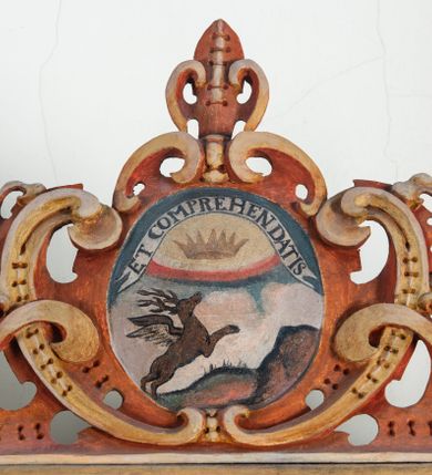 Zdjęcie nr 63: Umeblowanie zakrystii usytuowane jest wzdłuż ścian północnej, południowej i wschodniej pomieszczenia.  Na ścianie północnej, w części dolnej znajdują się trzy połączone ze sobą komody, każda o czterech szufladach, nakryte jednym blatem. W części górnej mieszczą się pięcioosiowe szafki z szufladami w cokole. Osie artykułowe są pilastrami hermowymi. Na osi środkowej szafka jest nieco wyższa i szersza z drzwiczkami dekorowanymi prostokątną, uszatą, oprofilowaną płyciną z malowanym przedstawieniem Chrystusa Eucharystycznego. Drzwiczki pozostałych szafek mają kształt stojących prostokątów i dekorowane są płycinami o wklęsłych narożach, zdobionymi gałązkami czerwonych róż, ułożonych w rokokowych wazonach. Ścianki zamknięte są niepełnym belkowaniem z gzymsem. W partii zwieńczenia osie artykułowane są cokolikami, na których ustawione są toczone, kuliste wazoniki. Pomiędzy nimi umieszczone są kartusze utworzone z ornamentu małżowinowo-chrząstkowego z malowanymi emblematami na owalnych medalionach, które ułożone są kolejno od lewej strony: 
1. Pionowo ustawiony miecz, ostrzem skierowany ku górze, połączony ze skrzyżowanymi berłem i dwoma kluczami, od których odchodzą fantazyjnie ułożone sznury w kolorze czerwonym. U góry napis na szarfie: „OBEDITE”.
2. W górnej części wyłaniająca się z chmur ręka trzymająca w dłoni węgielnicę i przymocowane do niej na łańcuszku tablice Dekalogu. Napis na szarfie: „OMNIA SVSTINET”.
3. Bóg Ojciec ukazany w półpostaci, lewą ręką opiera się na kuli ziemskiej, prawą czyni gest błogosławieństwa. 
4. Bujnie ulistnione, ciemnozielone drzewko spięte w dolnej części złotą formą w kształcie dwóch wywiniętych wolutek. Napis na szarfie: „GAVDET PATIENTIA DVRIS”. 
5. W górnej części obrazu z chmur wyłania się ręka, która zrzuca na ziemię iskrzący pocisk i dwa skrzyżowane pioruny, połączone parą białych skrzydeł. Napis „FORTIS VLTOR”.
 
Na ścianie środkowej, wschodniej znajduje się sarkofagowa mensa, powyżej parawanowa ścianka na profilowanym cokole, artykułowana pilastrami, pomiędzy którymi umieszczone są płyciny z kształcie leżących prostokątów z obrazami; ścianka zamknięta jest profilowanym gzymsem. W zwieńczeniu, na jej skrajach znajdują się owalne medaliony ujęte w kartusze z ornamentu małżowinowo-chrząstkowego. W medalionie po lewej stronie namalowane są litery alfa i omega na błękitnym tle oraz wstęga z napisem: „RENOVATUM A(NNO) D(OMINI) 1975”. Po prawej stronie analogiczny kartusz z literami w medalionie: „Ω / O / N” wpisane w formę krzyża, otoczonego niepełną aureolą; powyżej wstęga z napisem: „VIDENTEM AUDERE”. W płycinach obrazy przedstawiają świętych w ujęciu do pasa, zwróconych ku środkowi; od lewej:
1. Święty Demetriusz z włócznią opartą o prawy bark, ubrany w habit zakonu kanoników laterańskich od pokuty.
2. Święty Klet z aniołkiem, który trzyma w dłoni palmę męczeństwa i krzyż papieski. W prawym górnym narożu obrazu napis: „FAC HVIC SIGNO HONOREM”.
3. Święty Augustyn z gorejącym sercem na piersi i aniołkiem z łyżką i miseczką w dłoniach.
4. Święty ubrany w habit Marków, który trzyma w dłoni serce z krzyżem, podtrzymywane przez Chrystusa na obłokach – prawdopodobnie św. Cyriak, założyciel zakonu.
 
Na ścianie południowej znajduje się analogiczne umeblowanie, jak na ścianie północnej. W dolnej części dwie komody, a w miejscu trzeciej od wschodu szafka zdobiona dwiema uszatymi płycinami. Górna część mebla w przeciwieństwie do ściany północnej bez podwyższenia części środkowej. 
Na ścianie południowej:
1. Jasnobrązowa harfa na błękitnym tle i napis: „IN DOMINO”.
2. Ciemnobrązowy ptak i trzy podrywające się do lotu młode, w górnej części złote słońce i napis: „NON QUAE SVPER TERRAM.”
3. Po lewej stronie kompozycji wyłaniająca się z chmur ręka trzymająca skrzyżowane: miecz, czerwony krzyż i palmę. Napis: „NON ERVBESCO”.
4. W centrum przedstawienia krzak białej lilii o trzech rozgałęzieniach, w tle chmury w odcieniach koloru szaroniebieskiego. Napis na szarfie: „PER ARDVA DVLCIS”.
5. W lewej części kompozycji uskrzydlony jeleń, wspięty na tylnych nogach, po prawej stronie czarne i brązowe skały, w partii górnej otwarta korona, umieszczona pośrodku obłoku obwiedzionego biało-czerwonym pasem. Napis: „ET COMPREHENDATIS”.
 
W miejscu połączenia komód ścian północnej i południowej z dolną częścią konstrukcji na ścianie wschodniej znajdują się ukośnie ustawione, jednoskrzydłowe szafki o drzwiczkach dekorowanych prostokątną płyciną o wklęsłych narożach. Ścianki boczne części północnej i południowej zdobione są ukośną kratką. Powierzchnia szafek i komód pokryta jest polichromią imitującą marmur w kolorze beżowym, szarokremowym, różowym i rdzawym. Blaty malowane są farbą olejną w kolorze beżowym. Obramienia medalionów malowane w kolorze rdzawozłotym. Tło w większości medalionów w odcieniach błękitu, w górnych częściach majuskułowe napisy objaśniające przedstawienie, umieszczone w białych i półkoliście ułożonych szarfach. 