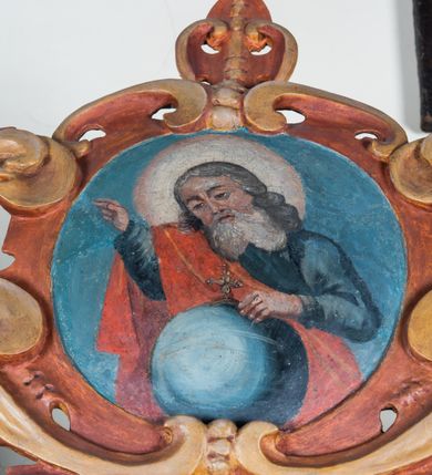 Zdjęcie nr 70: Umeblowanie zakrystii usytuowane jest wzdłuż ścian północnej, południowej i wschodniej pomieszczenia.  Na ścianie północnej, w części dolnej znajdują się trzy połączone ze sobą komody, każda o czterech szufladach, nakryte jednym blatem. W części górnej mieszczą się pięcioosiowe szafki z szufladami w cokole. Osie artykułowe są pilastrami hermowymi. Na osi środkowej szafka jest nieco wyższa i szersza z drzwiczkami dekorowanymi prostokątną, uszatą, oprofilowaną płyciną z malowanym przedstawieniem Chrystusa Eucharystycznego. Drzwiczki pozostałych szafek mają kształt stojących prostokątów i dekorowane są płycinami o wklęsłych narożach, zdobionymi gałązkami czerwonych róż, ułożonych w rokokowych wazonach. Ścianki zamknięte są niepełnym belkowaniem z gzymsem. W partii zwieńczenia osie artykułowane są cokolikami, na których ustawione są toczone, kuliste wazoniki. Pomiędzy nimi umieszczone są kartusze utworzone z ornamentu małżowinowo-chrząstkowego z malowanymi emblematami na owalnych medalionach, które ułożone są kolejno od lewej strony: 
1. Pionowo ustawiony miecz, ostrzem skierowany ku górze, połączony ze skrzyżowanymi berłem i dwoma kluczami, od których odchodzą fantazyjnie ułożone sznury w kolorze czerwonym. U góry napis na szarfie: „OBEDITE”.
2. W górnej części wyłaniająca się z chmur ręka trzymająca w dłoni węgielnicę i przymocowane do niej na łańcuszku tablice Dekalogu. Napis na szarfie: „OMNIA SVSTINET”.
3. Bóg Ojciec ukazany w półpostaci, lewą ręką opiera się na kuli ziemskiej, prawą czyni gest błogosławieństwa. 
4. Bujnie ulistnione, ciemnozielone drzewko spięte w dolnej części złotą formą w kształcie dwóch wywiniętych wolutek. Napis na szarfie: „GAVDET PATIENTIA DVRIS”. 
5. W górnej części obrazu z chmur wyłania się ręka, która zrzuca na ziemię iskrzący pocisk i dwa skrzyżowane pioruny, połączone parą białych skrzydeł. Napis „FORTIS VLTOR”.
 
Na ścianie środkowej, wschodniej znajduje się sarkofagowa mensa, powyżej parawanowa ścianka na profilowanym cokole, artykułowana pilastrami, pomiędzy którymi umieszczone są płyciny z kształcie leżących prostokątów z obrazami; ścianka zamknięta jest profilowanym gzymsem. W zwieńczeniu, na jej skrajach znajdują się owalne medaliony ujęte w kartusze z ornamentu małżowinowo-chrząstkowego. W medalionie po lewej stronie namalowane są litery alfa i omega na błękitnym tle oraz wstęga z napisem: „RENOVATUM A(NNO) D(OMINI) 1975”. Po prawej stronie analogiczny kartusz z literami w medalionie: „Ω / O / N” wpisane w formę krzyża, otoczonego niepełną aureolą; powyżej wstęga z napisem: „VIDENTEM AUDERE”. W płycinach obrazy przedstawiają świętych w ujęciu do pasa, zwróconych ku środkowi; od lewej:
1. Święty Demetriusz z włócznią opartą o prawy bark, ubrany w habit zakonu kanoników laterańskich od pokuty.
2. Święty Klet z aniołkiem, który trzyma w dłoni palmę męczeństwa i krzyż papieski. W prawym górnym narożu obrazu napis: „FAC HVIC SIGNO HONOREM”.
3. Święty Augustyn z gorejącym sercem na piersi i aniołkiem z łyżką i miseczką w dłoniach.
4. Święty ubrany w habit Marków, który trzyma w dłoni serce z krzyżem, podtrzymywane przez Chrystusa na obłokach – prawdopodobnie św. Cyriak, założyciel zakonu.
 
Na ścianie południowej znajduje się analogiczne umeblowanie, jak na ścianie północnej. W dolnej części dwie komody, a w miejscu trzeciej od wschodu szafka zdobiona dwiema uszatymi płycinami. Górna część mebla w przeciwieństwie do ściany północnej bez podwyższenia części środkowej. 
Na ścianie południowej:
1. Jasnobrązowa harfa na błękitnym tle i napis: „IN DOMINO”.
2. Ciemnobrązowy ptak i trzy podrywające się do lotu młode, w górnej części złote słońce i napis: „NON QUAE SVPER TERRAM.”
3. Po lewej stronie kompozycji wyłaniająca się z chmur ręka trzymająca skrzyżowane: miecz, czerwony krzyż i palmę. Napis: „NON ERVBESCO”.
4. W centrum przedstawienia krzak białej lilii o trzech rozgałęzieniach, w tle chmury w odcieniach koloru szaroniebieskiego. Napis na szarfie: „PER ARDVA DVLCIS”.
5. W lewej części kompozycji uskrzydlony jeleń, wspięty na tylnych nogach, po prawej stronie czarne i brązowe skały, w partii górnej otwarta korona, umieszczona pośrodku obłoku obwiedzionego biało-czerwonym pasem. Napis: „ET COMPREHENDATIS”.
 
W miejscu połączenia komód ścian północnej i południowej z dolną częścią konstrukcji na ścianie wschodniej znajdują się ukośnie ustawione, jednoskrzydłowe szafki o drzwiczkach dekorowanych prostokątną płyciną o wklęsłych narożach. Ścianki boczne części północnej i południowej zdobione są ukośną kratką. Powierzchnia szafek i komód pokryta jest polichromią imitującą marmur w kolorze beżowym, szarokremowym, różowym i rdzawym. Blaty malowane są farbą olejną w kolorze beżowym. Obramienia medalionów malowane w kolorze rdzawozłotym. Tło w większości medalionów w odcieniach błękitu, w górnych częściach majuskułowe napisy objaśniające przedstawienie, umieszczone w białych i półkoliście ułożonych szarfach. 