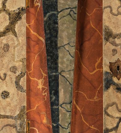 Zdjęcie nr 85: Umeblowanie zakrystii usytuowane jest wzdłuż ścian północnej, południowej i wschodniej pomieszczenia.  Na ścianie północnej, w części dolnej znajdują się trzy połączone ze sobą komody, każda o czterech szufladach, nakryte jednym blatem. W części górnej mieszczą się pięcioosiowe szafki z szufladami w cokole. Osie artykułowe są pilastrami hermowymi. Na osi środkowej szafka jest nieco wyższa i szersza z drzwiczkami dekorowanymi prostokątną, uszatą, oprofilowaną płyciną z malowanym przedstawieniem Chrystusa Eucharystycznego. Drzwiczki pozostałych szafek mają kształt stojących prostokątów i dekorowane są płycinami o wklęsłych narożach, zdobionymi gałązkami czerwonych róż, ułożonych w rokokowych wazonach. Ścianki zamknięte są niepełnym belkowaniem z gzymsem. W partii zwieńczenia osie artykułowane są cokolikami, na których ustawione są toczone, kuliste wazoniki. Pomiędzy nimi umieszczone są kartusze utworzone z ornamentu małżowinowo-chrząstkowego z malowanymi emblematami na owalnych medalionach, które ułożone są kolejno od lewej strony: 
1. Pionowo ustawiony miecz, ostrzem skierowany ku górze, połączony ze skrzyżowanymi berłem i dwoma kluczami, od których odchodzą fantazyjnie ułożone sznury w kolorze czerwonym. U góry napis na szarfie: „OBEDITE”.
2. W górnej części wyłaniająca się z chmur ręka trzymająca w dłoni węgielnicę i przymocowane do niej na łańcuszku tablice Dekalogu. Napis na szarfie: „OMNIA SVSTINET”.
3. Bóg Ojciec ukazany w półpostaci, lewą ręką opiera się na kuli ziemskiej, prawą czyni gest błogosławieństwa. 
4. Bujnie ulistnione, ciemnozielone drzewko spięte w dolnej części złotą formą w kształcie dwóch wywiniętych wolutek. Napis na szarfie: „GAVDET PATIENTIA DVRIS”. 
5. W górnej części obrazu z chmur wyłania się ręka, która zrzuca na ziemię iskrzący pocisk i dwa skrzyżowane pioruny, połączone parą białych skrzydeł. Napis „FORTIS VLTOR”.
 
Na ścianie środkowej, wschodniej znajduje się sarkofagowa mensa, powyżej parawanowa ścianka na profilowanym cokole, artykułowana pilastrami, pomiędzy którymi umieszczone są płyciny z kształcie leżących prostokątów z obrazami; ścianka zamknięta jest profilowanym gzymsem. W zwieńczeniu, na jej skrajach znajdują się owalne medaliony ujęte w kartusze z ornamentu małżowinowo-chrząstkowego. W medalionie po lewej stronie namalowane są litery alfa i omega na błękitnym tle oraz wstęga z napisem: „RENOVATUM A(NNO) D(OMINI) 1975”. Po prawej stronie analogiczny kartusz z literami w medalionie: „Ω / O / N” wpisane w formę krzyża, otoczonego niepełną aureolą; powyżej wstęga z napisem: „VIDENTEM AUDERE”. W płycinach obrazy przedstawiają świętych w ujęciu do pasa, zwróconych ku środkowi; od lewej:
1. Święty Demetriusz z włócznią opartą o prawy bark, ubrany w habit zakonu kanoników laterańskich od pokuty.
2. Święty Klet z aniołkiem, który trzyma w dłoni palmę męczeństwa i krzyż papieski. W prawym górnym narożu obrazu napis: „FAC HVIC SIGNO HONOREM”.
3. Święty Augustyn z gorejącym sercem na piersi i aniołkiem z łyżką i miseczką w dłoniach.
4. Święty ubrany w habit Marków, który trzyma w dłoni serce z krzyżem, podtrzymywane przez Chrystusa na obłokach – prawdopodobnie św. Cyriak, założyciel zakonu.
 
Na ścianie południowej znajduje się analogiczne umeblowanie, jak na ścianie północnej. W dolnej części dwie komody, a w miejscu trzeciej od wschodu szafka zdobiona dwiema uszatymi płycinami. Górna część mebla w przeciwieństwie do ściany północnej bez podwyższenia części środkowej. 
Na ścianie południowej:
1. Jasnobrązowa harfa na błękitnym tle i napis: „IN DOMINO”.
2. Ciemnobrązowy ptak i trzy podrywające się do lotu młode, w górnej części złote słońce i napis: „NON QUAE SVPER TERRAM.”
3. Po lewej stronie kompozycji wyłaniająca się z chmur ręka trzymająca skrzyżowane: miecz, czerwony krzyż i palmę. Napis: „NON ERVBESCO”.
4. W centrum przedstawienia krzak białej lilii o trzech rozgałęzieniach, w tle chmury w odcieniach koloru szaroniebieskiego. Napis na szarfie: „PER ARDVA DVLCIS”.
5. W lewej części kompozycji uskrzydlony jeleń, wspięty na tylnych nogach, po prawej stronie czarne i brązowe skały, w partii górnej otwarta korona, umieszczona pośrodku obłoku obwiedzionego biało-czerwonym pasem. Napis: „ET COMPREHENDATIS”.
 
W miejscu połączenia komód ścian północnej i południowej z dolną częścią konstrukcji na ścianie wschodniej znajdują się ukośnie ustawione, jednoskrzydłowe szafki o drzwiczkach dekorowanych prostokątną płyciną o wklęsłych narożach. Ścianki boczne części północnej i południowej zdobione są ukośną kratką. Powierzchnia szafek i komód pokryta jest polichromią imitującą marmur w kolorze beżowym, szarokremowym, różowym i rdzawym. Blaty malowane są farbą olejną w kolorze beżowym. Obramienia medalionów malowane w kolorze rdzawozłotym. Tło w większości medalionów w odcieniach błękitu, w górnych częściach majuskułowe napisy objaśniające przedstawienie, umieszczone w białych i półkoliście ułożonych szarfach. 