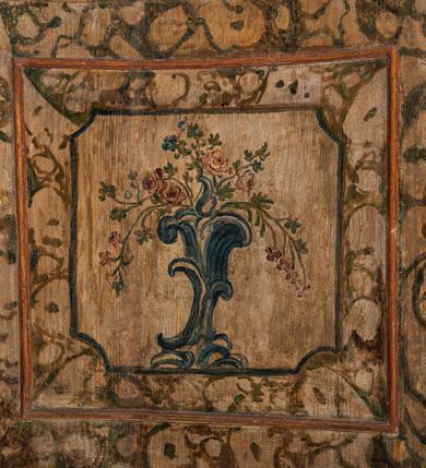 Zdjęcie nr 101: Umeblowanie zakrystii usytuowane jest wzdłuż ścian północnej, południowej i wschodniej pomieszczenia.  Na ścianie północnej, w części dolnej znajdują się trzy połączone ze sobą komody, każda o czterech szufladach, nakryte jednym blatem. W części górnej mieszczą się pięcioosiowe szafki z szufladami w cokole. Osie artykułowe są pilastrami hermowymi. Na osi środkowej szafka jest nieco wyższa i szersza z drzwiczkami dekorowanymi prostokątną, uszatą, oprofilowaną płyciną z malowanym przedstawieniem Chrystusa Eucharystycznego. Drzwiczki pozostałych szafek mają kształt stojących prostokątów i dekorowane są płycinami o wklęsłych narożach, zdobionymi gałązkami czerwonych róż, ułożonych w rokokowych wazonach. Ścianki zamknięte są niepełnym belkowaniem z gzymsem. W partii zwieńczenia osie artykułowane są cokolikami, na których ustawione są toczone, kuliste wazoniki. Pomiędzy nimi umieszczone są kartusze utworzone z ornamentu małżowinowo-chrząstkowego z malowanymi emblematami na owalnych medalionach, które ułożone są kolejno od lewej strony: 
1. Pionowo ustawiony miecz, ostrzem skierowany ku górze, połączony ze skrzyżowanymi berłem i dwoma kluczami, od których odchodzą fantazyjnie ułożone sznury w kolorze czerwonym. U góry napis na szarfie: „OBEDITE”.
2. W górnej części wyłaniająca się z chmur ręka trzymająca w dłoni węgielnicę i przymocowane do niej na łańcuszku tablice Dekalogu. Napis na szarfie: „OMNIA SVSTINET”.
3. Bóg Ojciec ukazany w półpostaci, lewą ręką opiera się na kuli ziemskiej, prawą czyni gest błogosławieństwa. 
4. Bujnie ulistnione, ciemnozielone drzewko spięte w dolnej części złotą formą w kształcie dwóch wywiniętych wolutek. Napis na szarfie: „GAVDET PATIENTIA DVRIS”. 
5. W górnej części obrazu z chmur wyłania się ręka, która zrzuca na ziemię iskrzący pocisk i dwa skrzyżowane pioruny, połączone parą białych skrzydeł. Napis „FORTIS VLTOR”.
 
Na ścianie środkowej, wschodniej znajduje się sarkofagowa mensa, powyżej parawanowa ścianka na profilowanym cokole, artykułowana pilastrami, pomiędzy którymi umieszczone są płyciny z kształcie leżących prostokątów z obrazami; ścianka zamknięta jest profilowanym gzymsem. W zwieńczeniu, na jej skrajach znajdują się owalne medaliony ujęte w kartusze z ornamentu małżowinowo-chrząstkowego. W medalionie po lewej stronie namalowane są litery alfa i omega na błękitnym tle oraz wstęga z napisem: „RENOVATUM A(NNO) D(OMINI) 1975”. Po prawej stronie analogiczny kartusz z literami w medalionie: „Ω / O / N” wpisane w formę krzyża, otoczonego niepełną aureolą; powyżej wstęga z napisem: „VIDENTEM AUDERE”. W płycinach obrazy przedstawiają świętych w ujęciu do pasa, zwróconych ku środkowi; od lewej:
1. Święty Demetriusz z włócznią opartą o prawy bark, ubrany w habit zakonu kanoników laterańskich od pokuty.
2. Święty Klet z aniołkiem, który trzyma w dłoni palmę męczeństwa i krzyż papieski. W prawym górnym narożu obrazu napis: „FAC HVIC SIGNO HONOREM”.
3. Święty Augustyn z gorejącym sercem na piersi i aniołkiem z łyżką i miseczką w dłoniach.
4. Święty ubrany w habit Marków, który trzyma w dłoni serce z krzyżem, podtrzymywane przez Chrystusa na obłokach – prawdopodobnie św. Cyriak, założyciel zakonu.
 
Na ścianie południowej znajduje się analogiczne umeblowanie, jak na ścianie północnej. W dolnej części dwie komody, a w miejscu trzeciej od wschodu szafka zdobiona dwiema uszatymi płycinami. Górna część mebla w przeciwieństwie do ściany północnej bez podwyższenia części środkowej. 
Na ścianie południowej:
1. Jasnobrązowa harfa na błękitnym tle i napis: „IN DOMINO”.
2. Ciemnobrązowy ptak i trzy podrywające się do lotu młode, w górnej części złote słońce i napis: „NON QUAE SVPER TERRAM.”
3. Po lewej stronie kompozycji wyłaniająca się z chmur ręka trzymająca skrzyżowane: miecz, czerwony krzyż i palmę. Napis: „NON ERVBESCO”.
4. W centrum przedstawienia krzak białej lilii o trzech rozgałęzieniach, w tle chmury w odcieniach koloru szaroniebieskiego. Napis na szarfie: „PER ARDVA DVLCIS”.
5. W lewej części kompozycji uskrzydlony jeleń, wspięty na tylnych nogach, po prawej stronie czarne i brązowe skały, w partii górnej otwarta korona, umieszczona pośrodku obłoku obwiedzionego biało-czerwonym pasem. Napis: „ET COMPREHENDATIS”.
 
W miejscu połączenia komód ścian północnej i południowej z dolną częścią konstrukcji na ścianie wschodniej znajdują się ukośnie ustawione, jednoskrzydłowe szafki o drzwiczkach dekorowanych prostokątną płyciną o wklęsłych narożach. Ścianki boczne części północnej i południowej zdobione są ukośną kratką. Powierzchnia szafek i komód pokryta jest polichromią imitującą marmur w kolorze beżowym, szarokremowym, różowym i rdzawym. Blaty malowane są farbą olejną w kolorze beżowym. Obramienia medalionów malowane w kolorze rdzawozłotym. Tło w większości medalionów w odcieniach błękitu, w górnych częściach majuskułowe napisy objaśniające przedstawienie, umieszczone w białych i półkoliście ułożonych szarfach. 