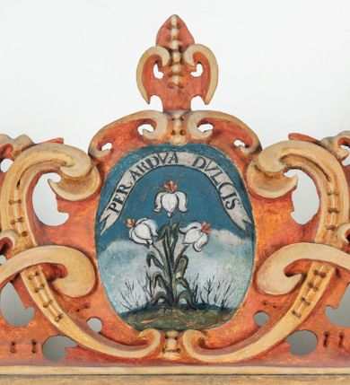 Zdjęcie nr 115: Umeblowanie zakrystii usytuowane jest wzdłuż ścian północnej, południowej i wschodniej pomieszczenia.  Na ścianie północnej, w części dolnej znajdują się trzy połączone ze sobą komody, każda o czterech szufladach, nakryte jednym blatem. W części górnej mieszczą się pięcioosiowe szafki z szufladami w cokole. Osie artykułowe są pilastrami hermowymi. Na osi środkowej szafka jest nieco wyższa i szersza z drzwiczkami dekorowanymi prostokątną, uszatą, oprofilowaną płyciną z malowanym przedstawieniem Chrystusa Eucharystycznego. Drzwiczki pozostałych szafek mają kształt stojących prostokątów i dekorowane są płycinami o wklęsłych narożach, zdobionymi gałązkami czerwonych róż, ułożonych w rokokowych wazonach. Ścianki zamknięte są niepełnym belkowaniem z gzymsem. W partii zwieńczenia osie artykułowane są cokolikami, na których ustawione są toczone, kuliste wazoniki. Pomiędzy nimi umieszczone są kartusze utworzone z ornamentu małżowinowo-chrząstkowego z malowanymi emblematami na owalnych medalionach, które ułożone są kolejno od lewej strony: 
1. Pionowo ustawiony miecz, ostrzem skierowany ku górze, połączony ze skrzyżowanymi berłem i dwoma kluczami, od których odchodzą fantazyjnie ułożone sznury w kolorze czerwonym. U góry napis na szarfie: „OBEDITE”.
2. W górnej części wyłaniająca się z chmur ręka trzymająca w dłoni węgielnicę i przymocowane do niej na łańcuszku tablice Dekalogu. Napis na szarfie: „OMNIA SVSTINET”.
3. Bóg Ojciec ukazany w półpostaci, lewą ręką opiera się na kuli ziemskiej, prawą czyni gest błogosławieństwa. 
4. Bujnie ulistnione, ciemnozielone drzewko spięte w dolnej części złotą formą w kształcie dwóch wywiniętych wolutek. Napis na szarfie: „GAVDET PATIENTIA DVRIS”. 
5. W górnej części obrazu z chmur wyłania się ręka, która zrzuca na ziemię iskrzący pocisk i dwa skrzyżowane pioruny, połączone parą białych skrzydeł. Napis „FORTIS VLTOR”.
 
Na ścianie środkowej, wschodniej znajduje się sarkofagowa mensa, powyżej parawanowa ścianka na profilowanym cokole, artykułowana pilastrami, pomiędzy którymi umieszczone są płyciny z kształcie leżących prostokątów z obrazami; ścianka zamknięta jest profilowanym gzymsem. W zwieńczeniu, na jej skrajach znajdują się owalne medaliony ujęte w kartusze z ornamentu małżowinowo-chrząstkowego. W medalionie po lewej stronie namalowane są litery alfa i omega na błękitnym tle oraz wstęga z napisem: „RENOVATUM A(NNO) D(OMINI) 1975”. Po prawej stronie analogiczny kartusz z literami w medalionie: „Ω / O / N” wpisane w formę krzyża, otoczonego niepełną aureolą; powyżej wstęga z napisem: „VIDENTEM AUDERE”. W płycinach obrazy przedstawiają świętych w ujęciu do pasa, zwróconych ku środkowi; od lewej:
1. Święty Demetriusz z włócznią opartą o prawy bark, ubrany w habit zakonu kanoników laterańskich od pokuty.
2. Święty Klet z aniołkiem, który trzyma w dłoni palmę męczeństwa i krzyż papieski. W prawym górnym narożu obrazu napis: „FAC HVIC SIGNO HONOREM”.
3. Święty Augustyn z gorejącym sercem na piersi i aniołkiem z łyżką i miseczką w dłoniach.
4. Święty ubrany w habit Marków, który trzyma w dłoni serce z krzyżem, podtrzymywane przez Chrystusa na obłokach – prawdopodobnie św. Cyriak, założyciel zakonu.
 
Na ścianie południowej znajduje się analogiczne umeblowanie, jak na ścianie północnej. W dolnej części dwie komody, a w miejscu trzeciej od wschodu szafka zdobiona dwiema uszatymi płycinami. Górna część mebla w przeciwieństwie do ściany północnej bez podwyższenia części środkowej. 
Na ścianie południowej:
1. Jasnobrązowa harfa na błękitnym tle i napis: „IN DOMINO”.
2. Ciemnobrązowy ptak i trzy podrywające się do lotu młode, w górnej części złote słońce i napis: „NON QUAE SVPER TERRAM.”
3. Po lewej stronie kompozycji wyłaniająca się z chmur ręka trzymająca skrzyżowane: miecz, czerwony krzyż i palmę. Napis: „NON ERVBESCO”.
4. W centrum przedstawienia krzak białej lilii o trzech rozgałęzieniach, w tle chmury w odcieniach koloru szaroniebieskiego. Napis na szarfie: „PER ARDVA DVLCIS”.
5. W lewej części kompozycji uskrzydlony jeleń, wspięty na tylnych nogach, po prawej stronie czarne i brązowe skały, w partii górnej otwarta korona, umieszczona pośrodku obłoku obwiedzionego biało-czerwonym pasem. Napis: „ET COMPREHENDATIS”.
 
W miejscu połączenia komód ścian północnej i południowej z dolną częścią konstrukcji na ścianie wschodniej znajdują się ukośnie ustawione, jednoskrzydłowe szafki o drzwiczkach dekorowanych prostokątną płyciną o wklęsłych narożach. Ścianki boczne części północnej i południowej zdobione są ukośną kratką. Powierzchnia szafek i komód pokryta jest polichromią imitującą marmur w kolorze beżowym, szarokremowym, różowym i rdzawym. Blaty malowane są farbą olejną w kolorze beżowym. Obramienia medalionów malowane w kolorze rdzawozłotym. Tło w większości medalionów w odcieniach błękitu, w górnych częściach majuskułowe napisy objaśniające przedstawienie, umieszczone w białych i półkoliście ułożonych szarfach. 