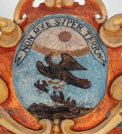 Zdjęcie nr 114: Umeblowanie zakrystii usytuowane jest wzdłuż ścian północnej, południowej i wschodniej pomieszczenia.  Na ścianie północnej, w części dolnej znajdują się trzy połączone ze sobą komody, każda o czterech szufladach, nakryte jednym blatem. W części górnej mieszczą się pięcioosiowe szafki z szufladami w cokole. Osie artykułowe są pilastrami hermowymi. Na osi środkowej szafka jest nieco wyższa i szersza z drzwiczkami dekorowanymi prostokątną, uszatą, oprofilowaną płyciną z malowanym przedstawieniem Chrystusa Eucharystycznego. Drzwiczki pozostałych szafek mają kształt stojących prostokątów i dekorowane są płycinami o wklęsłych narożach, zdobionymi gałązkami czerwonych róż, ułożonych w rokokowych wazonach. Ścianki zamknięte są niepełnym belkowaniem z gzymsem. W partii zwieńczenia osie artykułowane są cokolikami, na których ustawione są toczone, kuliste wazoniki. Pomiędzy nimi umieszczone są kartusze utworzone z ornamentu małżowinowo-chrząstkowego z malowanymi emblematami na owalnych medalionach, które ułożone są kolejno od lewej strony: 
1. Pionowo ustawiony miecz, ostrzem skierowany ku górze, połączony ze skrzyżowanymi berłem i dwoma kluczami, od których odchodzą fantazyjnie ułożone sznury w kolorze czerwonym. U góry napis na szarfie: „OBEDITE”.
2. W górnej części wyłaniająca się z chmur ręka trzymająca w dłoni węgielnicę i przymocowane do niej na łańcuszku tablice Dekalogu. Napis na szarfie: „OMNIA SVSTINET”.
3. Bóg Ojciec ukazany w półpostaci, lewą ręką opiera się na kuli ziemskiej, prawą czyni gest błogosławieństwa. 
4. Bujnie ulistnione, ciemnozielone drzewko spięte w dolnej części złotą formą w kształcie dwóch wywiniętych wolutek. Napis na szarfie: „GAVDET PATIENTIA DVRIS”. 
5. W górnej części obrazu z chmur wyłania się ręka, która zrzuca na ziemię iskrzący pocisk i dwa skrzyżowane pioruny, połączone parą białych skrzydeł. Napis „FORTIS VLTOR”.
 
Na ścianie środkowej, wschodniej znajduje się sarkofagowa mensa, powyżej parawanowa ścianka na profilowanym cokole, artykułowana pilastrami, pomiędzy którymi umieszczone są płyciny z kształcie leżących prostokątów z obrazami; ścianka zamknięta jest profilowanym gzymsem. W zwieńczeniu, na jej skrajach znajdują się owalne medaliony ujęte w kartusze z ornamentu małżowinowo-chrząstkowego. W medalionie po lewej stronie namalowane są litery alfa i omega na błękitnym tle oraz wstęga z napisem: „RENOVATUM A(NNO) D(OMINI) 1975”. Po prawej stronie analogiczny kartusz z literami w medalionie: „Ω / O / N” wpisane w formę krzyża, otoczonego niepełną aureolą; powyżej wstęga z napisem: „VIDENTEM AUDERE”. W płycinach obrazy przedstawiają świętych w ujęciu do pasa, zwróconych ku środkowi; od lewej:
1. Święty Demetriusz z włócznią opartą o prawy bark, ubrany w habit zakonu kanoników laterańskich od pokuty.
2. Święty Klet z aniołkiem, który trzyma w dłoni palmę męczeństwa i krzyż papieski. W prawym górnym narożu obrazu napis: „FAC HVIC SIGNO HONOREM”.
3. Święty Augustyn z gorejącym sercem na piersi i aniołkiem z łyżką i miseczką w dłoniach.
4. Święty ubrany w habit Marków, który trzyma w dłoni serce z krzyżem, podtrzymywane przez Chrystusa na obłokach – prawdopodobnie św. Cyriak, założyciel zakonu.
 
Na ścianie południowej znajduje się analogiczne umeblowanie, jak na ścianie północnej. W dolnej części dwie komody, a w miejscu trzeciej od wschodu szafka zdobiona dwiema uszatymi płycinami. Górna część mebla w przeciwieństwie do ściany północnej bez podwyższenia części środkowej. 
Na ścianie południowej:
1. Jasnobrązowa harfa na błękitnym tle i napis: „IN DOMINO”.
2. Ciemnobrązowy ptak i trzy podrywające się do lotu młode, w górnej części złote słońce i napis: „NON QUAE SVPER TERRAM.”
3. Po lewej stronie kompozycji wyłaniająca się z chmur ręka trzymająca skrzyżowane: miecz, czerwony krzyż i palmę. Napis: „NON ERVBESCO”.
4. W centrum przedstawienia krzak białej lilii o trzech rozgałęzieniach, w tle chmury w odcieniach koloru szaroniebieskiego. Napis na szarfie: „PER ARDVA DVLCIS”.
5. W lewej części kompozycji uskrzydlony jeleń, wspięty na tylnych nogach, po prawej stronie czarne i brązowe skały, w partii górnej otwarta korona, umieszczona pośrodku obłoku obwiedzionego biało-czerwonym pasem. Napis: „ET COMPREHENDATIS”.
 
W miejscu połączenia komód ścian północnej i południowej z dolną częścią konstrukcji na ścianie wschodniej znajdują się ukośnie ustawione, jednoskrzydłowe szafki o drzwiczkach dekorowanych prostokątną płyciną o wklęsłych narożach. Ścianki boczne części północnej i południowej zdobione są ukośną kratką. Powierzchnia szafek i komód pokryta jest polichromią imitującą marmur w kolorze beżowym, szarokremowym, różowym i rdzawym. Blaty malowane są farbą olejną w kolorze beżowym. Obramienia medalionów malowane w kolorze rdzawozłotym. Tło w większości medalionów w odcieniach błękitu, w górnych częściach majuskułowe napisy objaśniające przedstawienie, umieszczone w białych i półkoliście ułożonych szarfach. 