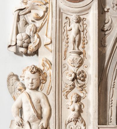 Zdjęcie nr 129: Umeblowanie zakrystii usytuowane jest wzdłuż ścian północnej, południowej i wschodniej pomieszczenia.  Na ścianie północnej, w części dolnej znajdują się trzy połączone ze sobą komody, każda o czterech szufladach, nakryte jednym blatem. W części górnej mieszczą się pięcioosiowe szafki z szufladami w cokole. Osie artykułowe są pilastrami hermowymi. Na osi środkowej szafka jest nieco wyższa i szersza z drzwiczkami dekorowanymi prostokątną, uszatą, oprofilowaną płyciną z malowanym przedstawieniem Chrystusa Eucharystycznego. Drzwiczki pozostałych szafek mają kształt stojących prostokątów i dekorowane są płycinami o wklęsłych narożach, zdobionymi gałązkami czerwonych róż, ułożonych w rokokowych wazonach. Ścianki zamknięte są niepełnym belkowaniem z gzymsem. W partii zwieńczenia osie artykułowane są cokolikami, na których ustawione są toczone, kuliste wazoniki. Pomiędzy nimi umieszczone są kartusze utworzone z ornamentu małżowinowo-chrząstkowego z malowanymi emblematami na owalnych medalionach, które ułożone są kolejno od lewej strony: 
1. Pionowo ustawiony miecz, ostrzem skierowany ku górze, połączony ze skrzyżowanymi berłem i dwoma kluczami, od których odchodzą fantazyjnie ułożone sznury w kolorze czerwonym. U góry napis na szarfie: „OBEDITE”.
2. W górnej części wyłaniająca się z chmur ręka trzymająca w dłoni węgielnicę i przymocowane do niej na łańcuszku tablice Dekalogu. Napis na szarfie: „OMNIA SVSTINET”.
3. Bóg Ojciec ukazany w półpostaci, lewą ręką opiera się na kuli ziemskiej, prawą czyni gest błogosławieństwa. 
4. Bujnie ulistnione, ciemnozielone drzewko spięte w dolnej części złotą formą w kształcie dwóch wywiniętych wolutek. Napis na szarfie: „GAVDET PATIENTIA DVRIS”. 
5. W górnej części obrazu z chmur wyłania się ręka, która zrzuca na ziemię iskrzący pocisk i dwa skrzyżowane pioruny, połączone parą białych skrzydeł. Napis „FORTIS VLTOR”.
 
Na ścianie środkowej, wschodniej znajduje się sarkofagowa mensa, powyżej parawanowa ścianka na profilowanym cokole, artykułowana pilastrami, pomiędzy którymi umieszczone są płyciny z kształcie leżących prostokątów z obrazami; ścianka zamknięta jest profilowanym gzymsem. W zwieńczeniu, na jej skrajach znajdują się owalne medaliony ujęte w kartusze z ornamentu małżowinowo-chrząstkowego. W medalionie po lewej stronie namalowane są litery alfa i omega na błękitnym tle oraz wstęga z napisem: „RENOVATUM A(NNO) D(OMINI) 1975”. Po prawej stronie analogiczny kartusz z literami w medalionie: „Ω / O / N” wpisane w formę krzyża, otoczonego niepełną aureolą; powyżej wstęga z napisem: „VIDENTEM AUDERE”. W płycinach obrazy przedstawiają świętych w ujęciu do pasa, zwróconych ku środkowi; od lewej:
1. Święty Demetriusz z włócznią opartą o prawy bark, ubrany w habit zakonu kanoników laterańskich od pokuty.
2. Święty Klet z aniołkiem, który trzyma w dłoni palmę męczeństwa i krzyż papieski. W prawym górnym narożu obrazu napis: „FAC HVIC SIGNO HONOREM”.
3. Święty Augustyn z gorejącym sercem na piersi i aniołkiem z łyżką i miseczką w dłoniach.
4. Święty ubrany w habit Marków, który trzyma w dłoni serce z krzyżem, podtrzymywane przez Chrystusa na obłokach – prawdopodobnie św. Cyriak, założyciel zakonu.
 
Na ścianie południowej znajduje się analogiczne umeblowanie, jak na ścianie północnej. W dolnej części dwie komody, a w miejscu trzeciej od wschodu szafka zdobiona dwiema uszatymi płycinami. Górna część mebla w przeciwieństwie do ściany północnej bez podwyższenia części środkowej. 
Na ścianie południowej:
1. Jasnobrązowa harfa na błękitnym tle i napis: „IN DOMINO”.
2. Ciemnobrązowy ptak i trzy podrywające się do lotu młode, w górnej części złote słońce i napis: „NON QUAE SVPER TERRAM.”
3. Po lewej stronie kompozycji wyłaniająca się z chmur ręka trzymająca skrzyżowane: miecz, czerwony krzyż i palmę. Napis: „NON ERVBESCO”.
4. W centrum przedstawienia krzak białej lilii o trzech rozgałęzieniach, w tle chmury w odcieniach koloru szaroniebieskiego. Napis na szarfie: „PER ARDVA DVLCIS”.
5. W lewej części kompozycji uskrzydlony jeleń, wspięty na tylnych nogach, po prawej stronie czarne i brązowe skały, w partii górnej otwarta korona, umieszczona pośrodku obłoku obwiedzionego biało-czerwonym pasem. Napis: „ET COMPREHENDATIS”.
 
W miejscu połączenia komód ścian północnej i południowej z dolną częścią konstrukcji na ścianie wschodniej znajdują się ukośnie ustawione, jednoskrzydłowe szafki o drzwiczkach dekorowanych prostokątną płyciną o wklęsłych narożach. Ścianki boczne części północnej i południowej zdobione są ukośną kratką. Powierzchnia szafek i komód pokryta jest polichromią imitującą marmur w kolorze beżowym, szarokremowym, różowym i rdzawym. Blaty malowane są farbą olejną w kolorze beżowym. Obramienia medalionów malowane w kolorze rdzawozłotym. Tło w większości medalionów w odcieniach błękitu, w górnych częściach majuskułowe napisy objaśniające przedstawienie, umieszczone w białych i półkoliście ułożonych szarfach. 