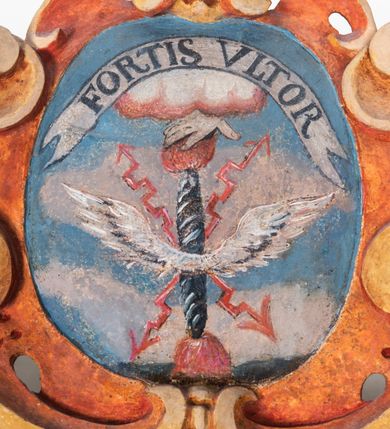 Zdjęcie nr 11: Umeblowanie zakrystii usytuowane jest wzdłuż ścian północnej, południowej i wschodniej pomieszczenia.  Na ścianie północnej, w części dolnej znajdują się trzy połączone ze sobą komody, każda o czterech szufladach, nakryte jednym blatem. W części górnej mieszczą się pięcioosiowe szafki z szufladami w cokole. Osie artykułowe są pilastrami hermowymi. Na osi środkowej szafka jest nieco wyższa i szersza z drzwiczkami dekorowanymi prostokątną, uszatą, oprofilowaną płyciną z malowanym przedstawieniem Chrystusa Eucharystycznego. Drzwiczki pozostałych szafek mają kształt stojących prostokątów i dekorowane są płycinami o wklęsłych narożach, zdobionymi gałązkami czerwonych róż, ułożonych w rokokowych wazonach. Ścianki zamknięte są niepełnym belkowaniem z gzymsem. W partii zwieńczenia osie artykułowane są cokolikami, na których ustawione są toczone, kuliste wazoniki. Pomiędzy nimi umieszczone są kartusze utworzone z ornamentu małżowinowo-chrząstkowego z malowanymi emblematami na owalnych medalionach, które ułożone są kolejno od lewej strony: 
1. Pionowo ustawiony miecz, ostrzem skierowany ku górze, połączony ze skrzyżowanymi berłem i dwoma kluczami, od których odchodzą fantazyjnie ułożone sznury w kolorze czerwonym. U góry napis na szarfie: „OBEDITE”.
2. W górnej części wyłaniająca się z chmur ręka trzymająca w dłoni węgielnicę i przymocowane do niej na łańcuszku tablice Dekalogu. Napis na szarfie: „OMNIA SVSTINET”.
3. Bóg Ojciec ukazany w półpostaci, lewą ręką opiera się na kuli ziemskiej, prawą czyni gest błogosławieństwa. 
4. Bujnie ulistnione, ciemnozielone drzewko spięte w dolnej części złotą formą w kształcie dwóch wywiniętych wolutek. Napis na szarfie: „GAVDET PATIENTIA DVRIS”. 
5. W górnej części obrazu z chmur wyłania się ręka, która zrzuca na ziemię iskrzący pocisk i dwa skrzyżowane pioruny, połączone parą białych skrzydeł. Napis „FORTIS VLTOR”.
 
Na ścianie środkowej, wschodniej znajduje się sarkofagowa mensa, powyżej parawanowa ścianka na profilowanym cokole, artykułowana pilastrami, pomiędzy którymi umieszczone są płyciny z kształcie leżących prostokątów z obrazami; ścianka zamknięta jest profilowanym gzymsem. W zwieńczeniu, na jej skrajach znajdują się owalne medaliony ujęte w kartusze z ornamentu małżowinowo-chrząstkowego. W medalionie po lewej stronie namalowane są litery alfa i omega na błękitnym tle oraz wstęga z napisem: „RENOVATUM A(NNO) D(OMINI) 1975”. Po prawej stronie analogiczny kartusz z literami w medalionie: „Ω / O / N” wpisane w formę krzyża, otoczonego niepełną aureolą; powyżej wstęga z napisem: „VIDENTEM AUDERE”. W płycinach obrazy przedstawiają świętych w ujęciu do pasa, zwróconych ku środkowi; od lewej:
1. Święty Demetriusz z włócznią opartą o prawy bark, ubrany w habit zakonu kanoników laterańskich od pokuty.
2. Święty Klet z aniołkiem, który trzyma w dłoni palmę męczeństwa i krzyż papieski. W prawym górnym narożu obrazu napis: „FAC HVIC SIGNO HONOREM”.
3. Święty Augustyn z gorejącym sercem na piersi i aniołkiem z łyżką i miseczką w dłoniach.
4. Święty ubrany w habit Marków, który trzyma w dłoni serce z krzyżem, podtrzymywane przez Chrystusa na obłokach – prawdopodobnie św. Cyriak, założyciel zakonu.
 
Na ścianie południowej znajduje się analogiczne umeblowanie, jak na ścianie północnej. W dolnej części dwie komody, a w miejscu trzeciej od wschodu szafka zdobiona dwiema uszatymi płycinami. Górna część mebla w przeciwieństwie do ściany północnej bez podwyższenia części środkowej. 
Na ścianie południowej:
1. Jasnobrązowa harfa na błękitnym tle i napis: „IN DOMINO”.
2. Ciemnobrązowy ptak i trzy podrywające się do lotu młode, w górnej części złote słońce i napis: „NON QUAE SVPER TERRAM.”
3. Po lewej stronie kompozycji wyłaniająca się z chmur ręka trzymająca skrzyżowane: miecz, czerwony krzyż i palmę. Napis: „NON ERVBESCO”.
4. W centrum przedstawienia krzak białej lilii o trzech rozgałęzieniach, w tle chmury w odcieniach koloru szaroniebieskiego. Napis na szarfie: „PER ARDVA DVLCIS”.
5. W lewej części kompozycji uskrzydlony jeleń, wspięty na tylnych nogach, po prawej stronie czarne i brązowe skały, w partii górnej otwarta korona, umieszczona pośrodku obłoku obwiedzionego biało-czerwonym pasem. Napis: „ET COMPREHENDATIS”.
 
W miejscu połączenia komód ścian północnej i południowej z dolną częścią konstrukcji na ścianie wschodniej znajdują się ukośnie ustawione, jednoskrzydłowe szafki o drzwiczkach dekorowanych prostokątną płyciną o wklęsłych narożach. Ścianki boczne części północnej i południowej zdobione są ukośną kratką. Powierzchnia szafek i komód pokryta jest polichromią imitującą marmur w kolorze beżowym, szarokremowym, różowym i rdzawym. Blaty malowane są farbą olejną w kolorze beżowym. Obramienia medalionów malowane w kolorze rdzawozłotym. Tło w większości medalionów w odcieniach błękitu, w górnych częściach majuskułowe napisy objaśniające przedstawienie, umieszczone w białych i półkoliście ułożonych szarfach. 