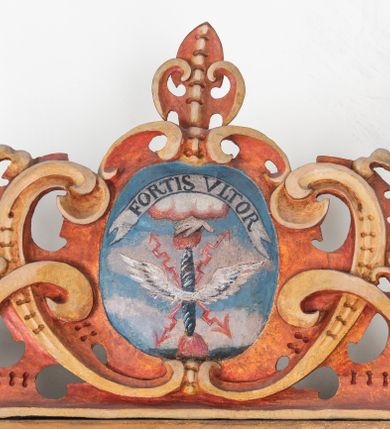 Zdjęcie nr 13: Umeblowanie zakrystii usytuowane jest wzdłuż ścian północnej, południowej i wschodniej pomieszczenia.  Na ścianie północnej, w części dolnej znajdują się trzy połączone ze sobą komody, każda o czterech szufladach, nakryte jednym blatem. W części górnej mieszczą się pięcioosiowe szafki z szufladami w cokole. Osie artykułowe są pilastrami hermowymi. Na osi środkowej szafka jest nieco wyższa i szersza z drzwiczkami dekorowanymi prostokątną, uszatą, oprofilowaną płyciną z malowanym przedstawieniem Chrystusa Eucharystycznego. Drzwiczki pozostałych szafek mają kształt stojących prostokątów i dekorowane są płycinami o wklęsłych narożach, zdobionymi gałązkami czerwonych róż, ułożonych w rokokowych wazonach. Ścianki zamknięte są niepełnym belkowaniem z gzymsem. W partii zwieńczenia osie artykułowane są cokolikami, na których ustawione są toczone, kuliste wazoniki. Pomiędzy nimi umieszczone są kartusze utworzone z ornamentu małżowinowo-chrząstkowego z malowanymi emblematami na owalnych medalionach, które ułożone są kolejno od lewej strony: 
1. Pionowo ustawiony miecz, ostrzem skierowany ku górze, połączony ze skrzyżowanymi berłem i dwoma kluczami, od których odchodzą fantazyjnie ułożone sznury w kolorze czerwonym. U góry napis na szarfie: „OBEDITE”.
2. W górnej części wyłaniająca się z chmur ręka trzymająca w dłoni węgielnicę i przymocowane do niej na łańcuszku tablice Dekalogu. Napis na szarfie: „OMNIA SVSTINET”.
3. Bóg Ojciec ukazany w półpostaci, lewą ręką opiera się na kuli ziemskiej, prawą czyni gest błogosławieństwa. 
4. Bujnie ulistnione, ciemnozielone drzewko spięte w dolnej części złotą formą w kształcie dwóch wywiniętych wolutek. Napis na szarfie: „GAVDET PATIENTIA DVRIS”. 
5. W górnej części obrazu z chmur wyłania się ręka, która zrzuca na ziemię iskrzący pocisk i dwa skrzyżowane pioruny, połączone parą białych skrzydeł. Napis „FORTIS VLTOR”.
 
Na ścianie środkowej, wschodniej znajduje się sarkofagowa mensa, powyżej parawanowa ścianka na profilowanym cokole, artykułowana pilastrami, pomiędzy którymi umieszczone są płyciny z kształcie leżących prostokątów z obrazami; ścianka zamknięta jest profilowanym gzymsem. W zwieńczeniu, na jej skrajach znajdują się owalne medaliony ujęte w kartusze z ornamentu małżowinowo-chrząstkowego. W medalionie po lewej stronie namalowane są litery alfa i omega na błękitnym tle oraz wstęga z napisem: „RENOVATUM A(NNO) D(OMINI) 1975”. Po prawej stronie analogiczny kartusz z literami w medalionie: „Ω / O / N” wpisane w formę krzyża, otoczonego niepełną aureolą; powyżej wstęga z napisem: „VIDENTEM AUDERE”. W płycinach obrazy przedstawiają świętych w ujęciu do pasa, zwróconych ku środkowi; od lewej:
1. Święty Demetriusz z włócznią opartą o prawy bark, ubrany w habit zakonu kanoników laterańskich od pokuty.
2. Święty Klet z aniołkiem, który trzyma w dłoni palmę męczeństwa i krzyż papieski. W prawym górnym narożu obrazu napis: „FAC HVIC SIGNO HONOREM”.
3. Święty Augustyn z gorejącym sercem na piersi i aniołkiem z łyżką i miseczką w dłoniach.
4. Święty ubrany w habit Marków, który trzyma w dłoni serce z krzyżem, podtrzymywane przez Chrystusa na obłokach – prawdopodobnie św. Cyriak, założyciel zakonu.
 
Na ścianie południowej znajduje się analogiczne umeblowanie, jak na ścianie północnej. W dolnej części dwie komody, a w miejscu trzeciej od wschodu szafka zdobiona dwiema uszatymi płycinami. Górna część mebla w przeciwieństwie do ściany północnej bez podwyższenia części środkowej. 
Na ścianie południowej:
1. Jasnobrązowa harfa na błękitnym tle i napis: „IN DOMINO”.
2. Ciemnobrązowy ptak i trzy podrywające się do lotu młode, w górnej części złote słońce i napis: „NON QUAE SVPER TERRAM.”
3. Po lewej stronie kompozycji wyłaniająca się z chmur ręka trzymająca skrzyżowane: miecz, czerwony krzyż i palmę. Napis: „NON ERVBESCO”.
4. W centrum przedstawienia krzak białej lilii o trzech rozgałęzieniach, w tle chmury w odcieniach koloru szaroniebieskiego. Napis na szarfie: „PER ARDVA DVLCIS”.
5. W lewej części kompozycji uskrzydlony jeleń, wspięty na tylnych nogach, po prawej stronie czarne i brązowe skały, w partii górnej otwarta korona, umieszczona pośrodku obłoku obwiedzionego biało-czerwonym pasem. Napis: „ET COMPREHENDATIS”.
 
W miejscu połączenia komód ścian północnej i południowej z dolną częścią konstrukcji na ścianie wschodniej znajdują się ukośnie ustawione, jednoskrzydłowe szafki o drzwiczkach dekorowanych prostokątną płyciną o wklęsłych narożach. Ścianki boczne części północnej i południowej zdobione są ukośną kratką. Powierzchnia szafek i komód pokryta jest polichromią imitującą marmur w kolorze beżowym, szarokremowym, różowym i rdzawym. Blaty malowane są farbą olejną w kolorze beżowym. Obramienia medalionów malowane w kolorze rdzawozłotym. Tło w większości medalionów w odcieniach błękitu, w górnych częściach majuskułowe napisy objaśniające przedstawienie, umieszczone w białych i półkoliście ułożonych szarfach. 