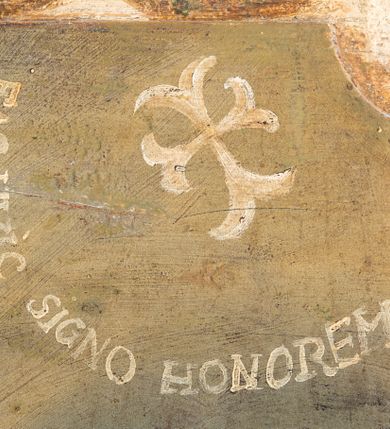 Zdjęcie nr 35: Umeblowanie zakrystii usytuowane jest wzdłuż ścian północnej, południowej i wschodniej pomieszczenia.  Na ścianie północnej, w części dolnej znajdują się trzy połączone ze sobą komody, każda o czterech szufladach, nakryte jednym blatem. W części górnej mieszczą się pięcioosiowe szafki z szufladami w cokole. Osie artykułowe są pilastrami hermowymi. Na osi środkowej szafka jest nieco wyższa i szersza z drzwiczkami dekorowanymi prostokątną, uszatą, oprofilowaną płyciną z malowanym przedstawieniem Chrystusa Eucharystycznego. Drzwiczki pozostałych szafek mają kształt stojących prostokątów i dekorowane są płycinami o wklęsłych narożach, zdobionymi gałązkami czerwonych róż, ułożonych w rokokowych wazonach. Ścianki zamknięte są niepełnym belkowaniem z gzymsem. W partii zwieńczenia osie artykułowane są cokolikami, na których ustawione są toczone, kuliste wazoniki. Pomiędzy nimi umieszczone są kartusze utworzone z ornamentu małżowinowo-chrząstkowego z malowanymi emblematami na owalnych medalionach, które ułożone są kolejno od lewej strony: 
1. Pionowo ustawiony miecz, ostrzem skierowany ku górze, połączony ze skrzyżowanymi berłem i dwoma kluczami, od których odchodzą fantazyjnie ułożone sznury w kolorze czerwonym. U góry napis na szarfie: „OBEDITE”.
2. W górnej części wyłaniająca się z chmur ręka trzymająca w dłoni węgielnicę i przymocowane do niej na łańcuszku tablice Dekalogu. Napis na szarfie: „OMNIA SVSTINET”.
3. Bóg Ojciec ukazany w półpostaci, lewą ręką opiera się na kuli ziemskiej, prawą czyni gest błogosławieństwa. 
4. Bujnie ulistnione, ciemnozielone drzewko spięte w dolnej części złotą formą w kształcie dwóch wywiniętych wolutek. Napis na szarfie: „GAVDET PATIENTIA DVRIS”. 
5. W górnej części obrazu z chmur wyłania się ręka, która zrzuca na ziemię iskrzący pocisk i dwa skrzyżowane pioruny, połączone parą białych skrzydeł. Napis „FORTIS VLTOR”.
 
Na ścianie środkowej, wschodniej znajduje się sarkofagowa mensa, powyżej parawanowa ścianka na profilowanym cokole, artykułowana pilastrami, pomiędzy którymi umieszczone są płyciny z kształcie leżących prostokątów z obrazami; ścianka zamknięta jest profilowanym gzymsem. W zwieńczeniu, na jej skrajach znajdują się owalne medaliony ujęte w kartusze z ornamentu małżowinowo-chrząstkowego. W medalionie po lewej stronie namalowane są litery alfa i omega na błękitnym tle oraz wstęga z napisem: „RENOVATUM A(NNO) D(OMINI) 1975”. Po prawej stronie analogiczny kartusz z literami w medalionie: „Ω / O / N” wpisane w formę krzyża, otoczonego niepełną aureolą; powyżej wstęga z napisem: „VIDENTEM AUDERE”. W płycinach obrazy przedstawiają świętych w ujęciu do pasa, zwróconych ku środkowi; od lewej:
1. Święty Demetriusz z włócznią opartą o prawy bark, ubrany w habit zakonu kanoników laterańskich od pokuty.
2. Święty Klet z aniołkiem, który trzyma w dłoni palmę męczeństwa i krzyż papieski. W prawym górnym narożu obrazu napis: „FAC HVIC SIGNO HONOREM”.
3. Święty Augustyn z gorejącym sercem na piersi i aniołkiem z łyżką i miseczką w dłoniach.
4. Święty ubrany w habit Marków, który trzyma w dłoni serce z krzyżem, podtrzymywane przez Chrystusa na obłokach – prawdopodobnie św. Cyriak, założyciel zakonu.
 
Na ścianie południowej znajduje się analogiczne umeblowanie, jak na ścianie północnej. W dolnej części dwie komody, a w miejscu trzeciej od wschodu szafka zdobiona dwiema uszatymi płycinami. Górna część mebla w przeciwieństwie do ściany północnej bez podwyższenia części środkowej. 
Na ścianie południowej:
1. Jasnobrązowa harfa na błękitnym tle i napis: „IN DOMINO”.
2. Ciemnobrązowy ptak i trzy podrywające się do lotu młode, w górnej części złote słońce i napis: „NON QUAE SVPER TERRAM.”
3. Po lewej stronie kompozycji wyłaniająca się z chmur ręka trzymająca skrzyżowane: miecz, czerwony krzyż i palmę. Napis: „NON ERVBESCO”.
4. W centrum przedstawienia krzak białej lilii o trzech rozgałęzieniach, w tle chmury w odcieniach koloru szaroniebieskiego. Napis na szarfie: „PER ARDVA DVLCIS”.
5. W lewej części kompozycji uskrzydlony jeleń, wspięty na tylnych nogach, po prawej stronie czarne i brązowe skały, w partii górnej otwarta korona, umieszczona pośrodku obłoku obwiedzionego biało-czerwonym pasem. Napis: „ET COMPREHENDATIS”.
 
W miejscu połączenia komód ścian północnej i południowej z dolną częścią konstrukcji na ścianie wschodniej znajdują się ukośnie ustawione, jednoskrzydłowe szafki o drzwiczkach dekorowanych prostokątną płyciną o wklęsłych narożach. Ścianki boczne części północnej i południowej zdobione są ukośną kratką. Powierzchnia szafek i komód pokryta jest polichromią imitującą marmur w kolorze beżowym, szarokremowym, różowym i rdzawym. Blaty malowane są farbą olejną w kolorze beżowym. Obramienia medalionów malowane w kolorze rdzawozłotym. Tło w większości medalionów w odcieniach błękitu, w górnych częściach majuskułowe napisy objaśniające przedstawienie, umieszczone w białych i półkoliście ułożonych szarfach. 