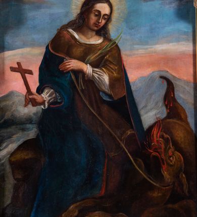 Zdjęcie nr 2: Obraz w kształcie stojącego prostokąta z wciętą odcinkowo krawędzią dolną i zakończonego łukiem odcinkowym z nadwieszeniem. Ukazuje siedzącą na skale św. Małgorzatę trzymającą na sznurku leżącego u jej stóp smoka. Jej twarz jest owalna, nos prosty, oczy otwarte a usta zamknięte, na głowie nosi długie, opadające na ramiona, falujące ciemne włosy. Wokół głowy nimb promienisty. Święta jest ubrana w białą koszulę z marszczonymi rękawami, brązową suknię i kamizelkę oraz niebieski płaszcz. W prawej ręce trzyma prosty krzyż, a w lewej smycz i palmę męczeństwa. Smok jest ukazany niemal frontalnie, z łapami wyciągniętymi na skale, uniesioną ku górze otwartą paszczą z językami ognia i widocznym tułowiem z ogonem. W tle górzysty krajobraz z różowo niebieskim-niebem i ciemnymi chmurami z główkami aniołków i silnym strumieniem światła padającym na świętą.  