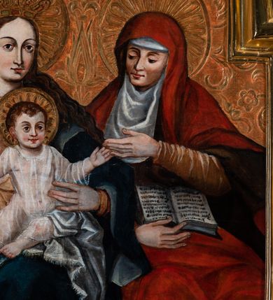 Zdjęcie nr 3: Obraz w kształcie stojącego prostokąta zamkniętego łukiem nadwieszonym półkolistym ozdobiony rocaillem. Obraz z przedstawieniem wielofiguralnym ukazuje Madonnę z Dzieciątkiem na kolanach oraz św. Annę Samotrzeć. Kobiety siedzą symetrycznie w środkowej części kompozycji, centralną przestrzeń zajmuje postać Dzieciątka. Maria jest odziana w złotą szatę i ciemnozielony płaszcz odkrywający lewe kolano. W prawej ręce wspartej na prawym udzie trzyma, a drugą podtrzymuje Chrystusa. Owalna twarz z wysokim czołem otoczona jest nimbem, oczy są migdałowate, z łukowato wygiętymi brwiami i długim wąskim nosem, usta małe i dość wąskie oraz krótki, wydany podbródek. Na głowie spoczywa złota korona zdobiona kamieniami szlachetnymi, a długie włosy opadają falami na plecy. Chrystus siedzi na lewym kolanie Marii, jest odziany w transparentną szatę. Ręce rozłożone są na boki, a otoczona złotym nimbem twarz zwrócona jest frontalnie, w lekkim uśmiechu. Postać św. Anny znajduje się po lewej stronie. Jest odziana w czerwony narzucony na głowę płaszcz. Pomarańczowa szata spodnia wystaje spod płaszcza na przedramieniu i w dolnej jego partii. Prawa ręka podtrzymuje otwartą księgę ułożoną na udach. Lewą dłonią kobieta dotyka ręki Chrystusa. Głowa otoczona jest złotym nimbem, twarz zwrócona w stronę Dzieciątka. Oczy opuszczone, skierowane w stronę stykających się rąk; brwi łukowato wygięte, nos smukły i długi, usta drobne. Głowę pod płaszczem otacza biała podwijka. W górnej partii puncowanego tła przedstawiona gołębica Ducha Świętego otoczona promieniami. Tło z motywami floralnymi uzupełnia przedstawiona w prawej części zdobiona kolumna z wazą. Tło w dolnych partiach malowane, pokryte w całości motywem florystycznym składającym się z różnych szczegółowo malowanych gatunków roślin. 
