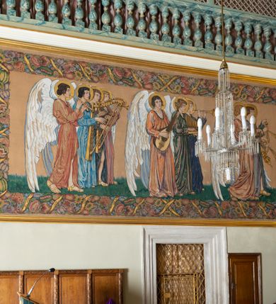 Zdjęcie nr 5: Obrazy w kształcie leżącego prostokąta przedstawiają procesję aniołów w trzech szeregach. Postacie w typie smukłych młodzieńców, ubranych w długie suknie w kolorze czerwonym, zielonym i niebieski, przepasane na biodrach, ze złotymi nimbami wokół głów i długimi białymi skrzydłami. Anioły w pierwszym rzędzie trzymają kadzielnice, w dalszych grają na różnych instrumentach: fletach, harfach, cytrze i cymbałach. Kompozycję obiega barwna, szeroka bordiura z różnych kwiatów.    