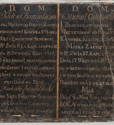 Zdjęcie nr 1: prostokątna płyta z czarnego marmuru. pole inskrypcyjne ujęte obramieniem w formie złoconej lamówki i podzielone symetrycznie na dwie części. Po prawej heraldycznej inskrypcja:

„D.O.M/X(dz)u Kletowi Barańskiemu / BŁOG(OSŁAWIONYCH) MECZEN(NIKÓW) OD POKUTY KANONIK(OWI) / PROBOSZCZOWI KOŚCIOŁA S(WIĘTE)GO MARKA / XIĘŻY EMERYTOW SENIOROWI / W R(OK)U ŻYCIA 65. A KAPŁAŃSTWA 41. / DNIA 19. STYCZNIA ROKU 1815. DO WIECZNOŚCI PRZENIESIONEMU / POBOŻNEMU I PRZYKŁADNEMU / MĘŻOWI W UPOMIN WZAIEMNEY PRZYIAZNI NA ZIEMI /X. Walenty Janikowski / DOMU XIĘŻY EMERYTOW PROBOSZCZ / NA SPOLNYM GROBOWCU TE PAMIĄTKĘ OBOK POŁOŻYŁ / IM”

Po lewej heraldycznej:

„D.O.M. /X. Michał Ostałowski / BŁOGOSŁAWIONYCH / MĘCZENNIKÓW OD POKUTY / KANONIK KOŚCIOŁA SWIĘT(EGO) / MARKA ZAKRYSTYAN / W R(OK)U ZYCIA 87. KAPŁAŃSTWA 62. / DNIA 17 WRZEŚNIA R(OK)U 1831. / DO WIECZNOŚCI PRZENIESIONY I W TYM KOŚCIELE POCHOWANY / POBOŻNY ORAZ PRZYKŁADNY/MĄŻ / PROŚ ZA NIM CZYTELNIKU / BOGA O MIŁOSIERDZIE/ABYŚ GO I TY DOSTĄPIŁ.”