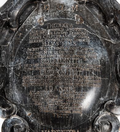 Zdjęcie nr 2: Marmurowa płyta o owalnym kształcie ujęta w obramienie z ornamentu kartuszowo-zawijanego z wolutowymi motywami w górnej partii przyjmującymi formę zwróconych ku sobie zgeometryzowanych orlich głów. Zwieńczenie z cokołem i obeliskiem na trzech kulach. Na cokole dwa owalne ryte pola, na jednym po lewej stronie godło herbu Kościesza. W polu inskrypcja: "D(EO) O(PTIMO) M(AXIMO) / THEODORA / A DĘBIANI ZAMBRZICKA STEMMATIS / RAWICZ PATRE ERASMO DĘBIENSKI / MATRE CRISTINA A SKIWI ORIVNDA / RELIGIONE PROSAPIA FORMA BENEFACTIS / ILLVSTRIS / IN ORTV VITAE ET CONIVGII ANNO A PARTV / VIRGINIS MDCLX DIE VI MAI IN PVLVERE SVO / AD LAPIDEM HVNC FATIGATA AERVMNIS VITAE / OBDORMIVIT / IN OCCASV NOVISSIMAE DIEIRVRSVS AD CLANGOREM / TVBAE ANIMATVRA ET AETERNVM VIGILATVRA / EXPERGEFI ET / AMICE VT  NOCTEM HANC SPECTRIS NON INQVIE[T] TAM / SOMNO NON IN SIPIDAM EXPERIARE TALAMV(M) PELLINATIONIS / TVAE TVTVS RECTE FACTOR(M) CONSCIENTIA MEMINERIS INGREDI / IOANNES / A ZAMBRZICA ZAMBRZICKI / SECRETARVS REGIVS ARAM / HANC DOTATAM MAGNO / DEO SALVATORI MANU/SOLAEVM POSTHVMAE / CONIVGIS MEMORIAE SACRA / FECIT."
