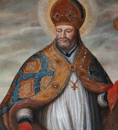 Zdjęcie nr 2: Obraz uzyskał kształt stojącego prostokąta w złoconej, profilowanej ramie. W centrum kompozycji, na tle pejzażu ukazano św. Mikołaj jako starszego mężczyznę w stroju biskupim stojący obok drewnianego cebra z trzema chłopcami. Święty został ujęty w trzech czwartych w lewo. Mikołaj w lewym ręku trzyma złoty pastorał o krzywaśni utworzonej z wici roślinnej, prawą zaś podaje jednemu z chłopców złotą bryłę. Biskup ma pociągłą twarz o zapadniętych policzkach otoczoną siwiejącą krótką brodą. Jego twarz charakteryzuje jasna karnacja, wydatny nos i usta. Spojrzenie nieznacznie przymkniętych oczy kieruje w stronę chłopców. Mikołaj ubrany jest w ciemną, marszczoną sutannę, białą rokietę ze spodem i rękawami dekorowaną koronką oraz w ozdobną kapę z szeroką, ochrową bortą zdobioną malowaną imitacją kameryzacji. Kapę zdobi powtarzający się ochrowy motyw stylizowanej rozety w romboidalnym obramieniu na niebieskim tle. Spod kapy widać na piersi niewielki złoty krzyż pektoralny. Na głowie biskup ma ciemnoochrową infułę ozdobioną dwoma klejnotami z kamieniami szlachetnymi, a na rękach czerwone rękawiczki pontyfikalne. Chłopcy w cebrze ukazani zostali w dynamicznych pozach, z odsłoniętymi torsami. Mają pucułowate twarze o rumianych policzkach oraz wydatnych nosach i pełnych ustach. Ubrani są w luźno udrapowane szaty – czerwoną, jasnoszarą i ciemnogranatową. Chłopiec w czerwonej szacie odbiera od świętego złotą bryłę trzymając już w pole szaty dwie pozostałe. Siedzący obok niego chłopiec w szarawej szacie trzyma jedną bryłę złota, natomiast widoczny za nimi trzeci w ciemnogranatowej szacie ma modlitewnie złożone ręce. W tle z prawej strony kompozycji ukazany został fragment zabudowań kościelnych, a powyżej szare niebo. 