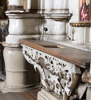 Zdjęcie nr 3: Przyścienny ołtarz Matki Boskiej Częstochowskiej uzyskał formę architektonicznej nastawy jednokondygnacyjnej, jednoosiowej ze zwieńczeniem. Drewniana mensa z portatylem flankowana przez dwustrefowy wklęsło-wypukły cokół wspiera się na ażurowym, konsolowym stipesie ołtarzowym, dekorowanym ornamentami rocalliowymi. Kondygnacja wsparta na dwustrefowym cokole została ujęta dwiema parami pilastrów zwróconych delikatnie do wewnątrz oraz silnie wysuniętą do przodu parą kolumn o kapitelach kompozytowych. Podpory dźwigają belkowanie o wklęsło-wypukłej linii. Nad polem środkowym belkowanie jest przerwane, a na osiach podpór wyłamane. Na przedłużeniu kolumn na belkowaniu usytuowano wolutowe przyczółki dekorowane rocalliem, stanowiących postumenty do skradzionych figur aniołów. W polu środkowym umieszczono obecnie obraz Matki Boskiej Nieustającej Pomocy Najświętszego, ujęty profilowaną, złoconą ramą w formie stojącego prostokąta zamkniętego łukiem półkolistym nadwieszonym z uskokiem, dekorowaną ornamentem rocalliowym. Poniżej obrazu pomiędzy dwiema rocalliowymi konsolami widnieje zdjęcie obrazu św. Jana Nepomucena. Zwieńczenie uzyskało formę leżącego prostokąta o wklęsłych, wolutowych bokach przechodzących u góry we wklęsło-wypukłe belkowanie, przyjmujące nad polem formę łuku falistego. W polu zwieńczenia znalazło się zdjęcie obrazu ze św. Józefem ujęte we wklęsło-wypukłą, profilowaną i złoconą ramę. Pilastry kondygnacji ozdobiono kapitelami z rocaille, a ich trzony udekorowano złoconymi zwisami utworzonymi z rocaille, rozet i liści. Całość struktury polichromowano na biało, a ornamenty i profile zostały wyzłocone. 