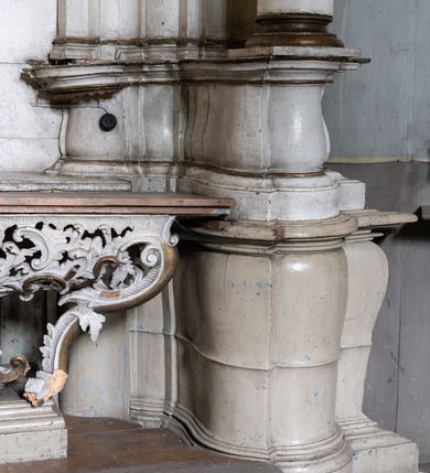 Zdjęcie nr 6: Przyścienny ołtarz Matki Boskiej Częstochowskiej uzyskał formę architektonicznej nastawy jednokondygnacyjnej, jednoosiowej ze zwieńczeniem. Drewniana mensa z portatylem flankowana przez dwustrefowy wklęsło-wypukły cokół wspiera się na ażurowym, konsolowym stipesie ołtarzowym, dekorowanym ornamentami rocalliowymi. Kondygnacja wsparta na dwustrefowym cokole została ujęta dwiema parami pilastrów zwróconych delikatnie do wewnątrz oraz silnie wysuniętą do przodu parą kolumn o kapitelach kompozytowych. Podpory dźwigają belkowanie o wklęsło-wypukłej linii. Nad polem środkowym belkowanie jest przerwane, a na osiach podpór wyłamane. Na przedłużeniu kolumn na belkowaniu usytuowano wolutowe przyczółki dekorowane rocalliem, stanowiących postumenty do skradzionych figur aniołów. W polu środkowym umieszczono obecnie obraz Matki Boskiej Nieustającej Pomocy Najświętszego, ujęty profilowaną, złoconą ramą w formie stojącego prostokąta zamkniętego łukiem półkolistym nadwieszonym z uskokiem, dekorowaną ornamentem rocalliowym. Poniżej obrazu pomiędzy dwiema rocalliowymi konsolami widnieje zdjęcie obrazu św. Jana Nepomucena. Zwieńczenie uzyskało formę leżącego prostokąta o wklęsłych, wolutowych bokach przechodzących u góry we wklęsło-wypukłe belkowanie, przyjmujące nad polem formę łuku falistego. W polu zwieńczenia znalazło się zdjęcie obrazu ze św. Józefem ujęte we wklęsło-wypukłą, profilowaną i złoconą ramę. Pilastry kondygnacji ozdobiono kapitelami z rocaille, a ich trzony udekorowano złoconymi zwisami utworzonymi z rocaille, rozet i liści. Całość struktury polichromowano na biało, a ornamenty i profile zostały wyzłocone. 