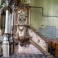 Zdjęcie nr 1: Przyścienną, wiszącą ambonę z dostępem w postaci jednobiegowych schodów z balustradą od strony prezbiterium usytuowano przy łuku tęczowym na ścianie północnej. Ambona składa się kosz na planie ściętego sześcioboku oraz zaplecka zwieńczonego gołębicą Ducha Świętego w promienistym otoku. Kosz ambony został w dolnej części zamknięty wyłamanym na jego ścięciach cokołem dekorowanym rytmicznie usytuowanymi płaskorzeźbionymi palmetami, tworząc dekoracyjny fryz, który poprowadzono również jako cokół balustrady schodów. Odpowiednikiem ukształtowania cokołu jest wieńczące kosz wyłamane belkowanie, także przechodzące na balustradę schodów, ozdobione w górnej partii mniejszymi liśćmi palmetowymi. Kosz od spodu zamknięty jest gładkimi spływami ujętymi wiszącą, liściastą szyszką. Ścięte boki kosza udekorowano spływami wolutowymi, ozdobionymi u spodu stylizowanym liściem akantu. W płycinach pomiędzy wolutami umieszczono złocone, wiszące gałązki różane. Zaplecek uzyskał kształt stojącego prostokąta flankowany dwoma pilastrami o głowicach pozbawionych dekoracji, na których wsparto przerwane belkowanie. W przerwie belkowania usytuowano złocony, promienisty otok z wyobrażeniem srebrzonej gołębicy Ducha Świętego. Trzony pilastrów zdobi wisząca gałązka liściasta, natomiast płycinę pomiędzy pilastrami motyw roślinny ułożony w formie arabeski. Strukturę pomalowano w dwóch odcieniach beżu, zaś elementy ornamentalne wyzłocono.