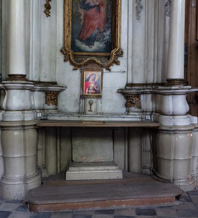 Zdjęcie nr 4: Przyścienny ołtarz Najświętszego Serca Pana Jezusa uzyskał formę architektonicznej nastawy jednokondygnacyjnej, jednoosiowej ze zwieńczeniem. Drewniana mensa z portatylem flankowana przez dwustrefowy wklęsło-wypukły cokół retabulum pierwotnie wspierała się na ażurowym, konsolowym stipesie ołtarzowym, dekorowanym ornamentami rocalliowymi. Kondygnacja wsparta na dwustrefowym cokole została ujęta dwiema parami pilastrów zwróconych delikatnie do wewnątrz oraz silnie wysuniętą do przodu parą kolumn o kapitelach kompozytowych. Podpory dźwigają belkowanie o wklęsło-wypukłej linii. Nad polem środkowym belkowanie jest przerwane, a na osiach podpór wyłamane. Na przedłużeniu kolumn na belkowaniu usytuowano wolutowe przyczółki dekorowane rocalliem, stanowiących postumenty do skradzionych figur aniołów. W polu środkowym umieszczono obraz Najświętszego Serca Pana Jezusa, ujęty profilowaną, złoconą ramą w formie stojącego prostokąta zamkniętego łukiem półkolistym nadwieszonym z uskokiem. Poniżej obrazu pomiędzy dwiema rocalliowymi konsolami widnieje zdjęcie obrazu św. Katarzyny Aleksandryjskiej. Zwieńczenie uzyskało formę leżącego prostokąta o wklęsłych, wolutowych bokach przechodzących u góry we wklęsło-wypukłe belkowanie, przyjmujące nad polem formę łuku falistego. W polu zwieńczenia znalazło się zdjęcie obrazu ze św. Sebastianem ujęte we wklęsło-wypukłą, profilowaną i złoconą ramę. Na szczycie w rocalliowym kartuszu wyobrażono złocony chrystogram "IHS" w srebrnym polu. Pilastry kondygnacji ozdobiono kapitelami z rocaille, a ich trzony udekorowano złoconymi zwisami utworzonymi z rocaille, rozet i liści. Całość struktury polichromowano na biało, a ornamenty i profile zostały wyzłocone. 