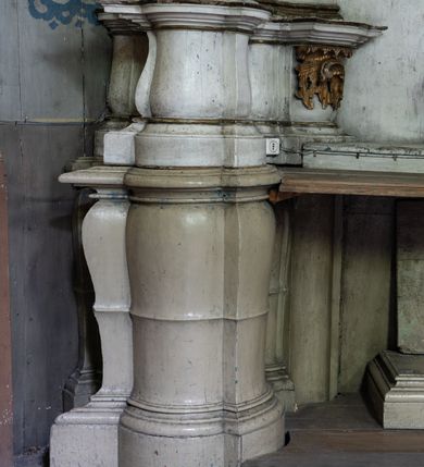Zdjęcie nr 11: Przyścienny ołtarz Najświętszego Serca Pana Jezusa uzyskał formę architektonicznej nastawy jednokondygnacyjnej, jednoosiowej ze zwieńczeniem. Drewniana mensa z portatylem flankowana przez dwustrefowy wklęsło-wypukły cokół retabulum pierwotnie wspierała się na ażurowym, konsolowym stipesie ołtarzowym, dekorowanym ornamentami rocalliowymi. Kondygnacja wsparta na dwustrefowym cokole została ujęta dwiema parami pilastrów zwróconych delikatnie do wewnątrz oraz silnie wysuniętą do przodu parą kolumn o kapitelach kompozytowych. Podpory dźwigają belkowanie o wklęsło-wypukłej linii. Nad polem środkowym belkowanie jest przerwane, a na osiach podpór wyłamane. Na przedłużeniu kolumn na belkowaniu usytuowano wolutowe przyczółki dekorowane rocalliem, stanowiących postumenty do skradzionych figur aniołów. W polu środkowym umieszczono obraz Najświętszego Serca Pana Jezusa, ujęty profilowaną, złoconą ramą w formie stojącego prostokąta zamkniętego łukiem półkolistym nadwieszonym z uskokiem. Poniżej obrazu pomiędzy dwiema rocalliowymi konsolami widnieje zdjęcie obrazu św. Katarzyny Aleksandryjskiej. Zwieńczenie uzyskało formę leżącego prostokąta o wklęsłych, wolutowych bokach przechodzących u góry we wklęsło-wypukłe belkowanie, przyjmujące nad polem formę łuku falistego. W polu zwieńczenia znalazło się zdjęcie obrazu ze św. Sebastianem ujęte we wklęsło-wypukłą, profilowaną i złoconą ramę. Na szczycie w rocalliowym kartuszu wyobrażono złocony chrystogram "IHS" w srebrnym polu. Pilastry kondygnacji ozdobiono kapitelami z rocaille, a ich trzony udekorowano złoconymi zwisami utworzonymi z rocaille, rozet i liści. Całość struktury polichromowano na biało, a ornamenty i profile zostały wyzłocone. 