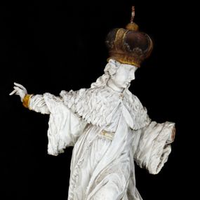 Zdjęcie nr 1: Rzeźba przedstawia całopostaciowe wyobrażenie św. Kazimierza Królewicza. Święty został ukazany w mocnym kontrapoście w trzech czwartych w prawo. Obie uniesione ręce ma odsunięte od tułowia. Kazimierz został ukazany jako młodzieniec o pociągłej twarzy z wydatnym nosem i ustami. Jego głowę otaczają długie, falujące włosy opadające na plecy. Na głowie ma zamkniętą, złoconą koronę z globem i krzyżykiem. Ubrany jest w przewiązaną tunikę i rozwiany, mocno drapowany płaszcz z gronostajowym kołnierzem. Spod tuniki widać nogi obute w złocone trzewiki. Rzeźba w całości polichromowana na biało, ze złoconymi dodatkami.  