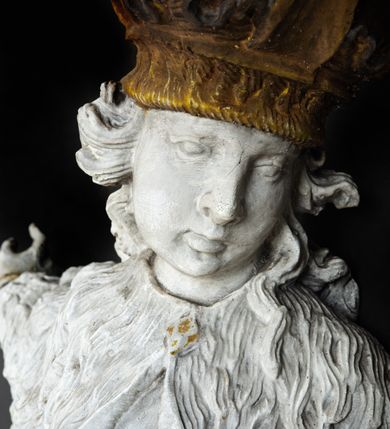 Zdjęcie nr 3: Rzeźba przedstawia całopostaciowe wyobrażenie św. Kazimierza Królewicza. Święty został ukazany w mocnym kontrapoście w trzech czwartych w prawo. Obie uniesione ręce ma odsunięte od tułowia. Kazimierz został ukazany jako młodzieniec o pociągłej twarzy z wydatnym nosem i ustami. Jego głowę otaczają długie, falujące włosy opadające na plecy. Na głowie ma zamkniętą, złoconą koronę z globem i krzyżykiem. Ubrany jest w przewiązaną tunikę i rozwiany, mocno drapowany płaszcz z gronostajowym kołnierzem. Spod tuniki widać nogi obute w złocone trzewiki. Rzeźba w całości polichromowana na biało, ze złoconymi dodatkami.  