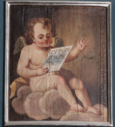 Zdjęcie nr 5: Parapet chóru muzycznego wsparty na dwóch filarach, o kanelowanych trzonach w górnej części. Balustrada o wypukłej środkowej partii, na niskim cokole, podzielona na pola pilastrami, dźwigającymi profilowany gzyms stanowiący poręcz. W polach płyciny w formie stojącego prostokąta ujętego ramą, z malowanymi przedstawieniami muzykujących aniołów siedzących na obłokach. Aniołki w kolejności od lewej strony trzymają waltornię, wiolonczelę, skrzypce, następne dwa nuty, później skrzypce, flet poprzeczny i waltornię. 