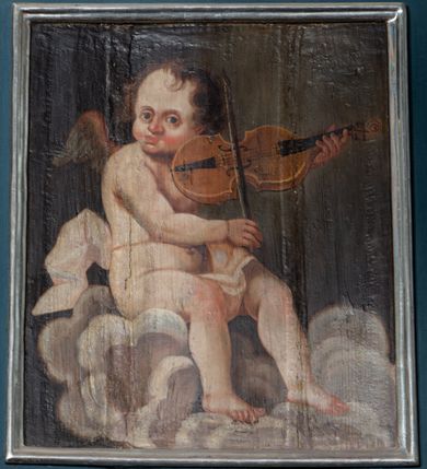 Zdjęcie nr 7: Parapet chóru muzycznego wsparty na dwóch filarach, o kanelowanych trzonach w górnej części. Balustrada o wypukłej środkowej partii, na niskim cokole, podzielona na pola pilastrami, dźwigającymi profilowany gzyms stanowiący poręcz. W polach płyciny w formie stojącego prostokąta ujętego ramą, z malowanymi przedstawieniami muzykujących aniołów siedzących na obłokach. Aniołki w kolejności od lewej strony trzymają waltornię, wiolonczelę, skrzypce, następne dwa nuty, później skrzypce, flet poprzeczny i waltornię. 