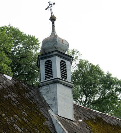 Zdjęcie nr 41: Drewniany kościół pw. św. Mikołaja w Polance jest budowlą orientowaną. Do prostokątnej nawy przylega węższe, wydłużone, trójbocznie zamknięte prezbiterium z piętrową zakrystią na osi o poligonalnym zamknięciu. Do zakrystii przylega od południa kruchta. Fragment północnej ściany prezbiterium jest murowany. Od zachodu do nawy dobudowano czworoboczną wieżę poprzedzoną przedsionkiem, który również dostawiono do nawy od południa. Prezbiterium i nawę wzniesiono na zrąb, natomiast wieżę w konstrukcji słupowej. Wieża na rzucie kwadratu posiada dwie kondygnacje. Dolna jest tej samej szerokości co nawa, górna natomiast znacznie węższa. Jej masyw podzielono smukłymi pilastrami i lizenami, zaś poniżej profilowanego gzymsu koronującego umieszczono wyrzynaną w desce koronkę. Kondygnacje oddzielono daszkiem gontowym zlewającym się po bokach z dachem kościoła. Wieżę nakryto kopulastym hełmem blaszanym, zwieńczonym blaszanym obeliskiem z krzyżem. Prezbiterium i nawę nakryto eternitowym dachem siodłowym podkreślonym profilowanym gzymsem. Nad nawą w części wschodniej zainstalowano wieżyczkę na sygnaturkę w formie wielobocznego graniastosłupa przykrytego cebulastą banią z krzyżem. Dokoła kościoła założono daszek gontowy chroniący podwaliny. Pod kościołem urządzono kryptę grzebalną. Wnętrze kościoła artykułowano za pomocą pilastrów i gzymsu. Całość nakryto stropem z fasetą. Otwór tęczowy uzyskał kształt trójlistnego, ściętego łuku, wspartego na filarkach ustawionych na profilowanej belce zawieszonej na kroksztynach. W części zachodniej nawy urządzono chór muzyczny, wsparty na dwóch kolumnach jońskich z przedpiersiem rozczłonkowanym balasami. We wnętrzu ustawiono ołtarz główny i dwa ołtarze boczne oraz ambonę, a na chórze muzycznym zainstalowano prospekt organowy.