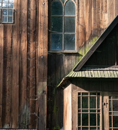 Zdjęcie nr 54: Drewniany kościół pw. św. Mikołaja w Polance jest budowlą orientowaną. Do prostokątnej nawy przylega węższe, wydłużone, trójbocznie zamknięte prezbiterium z piętrową zakrystią na osi o poligonalnym zamknięciu. Do zakrystii przylega od południa kruchta. Fragment północnej ściany prezbiterium jest murowany. Od zachodu do nawy dobudowano czworoboczną wieżę poprzedzoną przedsionkiem, który również dostawiono do nawy od południa. Prezbiterium i nawę wzniesiono na zrąb, natomiast wieżę w konstrukcji słupowej. Wieża na rzucie kwadratu posiada dwie kondygnacje. Dolna jest tej samej szerokości co nawa, górna natomiast znacznie węższa. Jej masyw podzielono smukłymi pilastrami i lizenami, zaś poniżej profilowanego gzymsu koronującego umieszczono wyrzynaną w desce koronkę. Kondygnacje oddzielono daszkiem gontowym zlewającym się po bokach z dachem kościoła. Wieżę nakryto kopulastym hełmem blaszanym, zwieńczonym blaszanym obeliskiem z krzyżem. Prezbiterium i nawę nakryto eternitowym dachem siodłowym podkreślonym profilowanym gzymsem. Nad nawą w części wschodniej zainstalowano wieżyczkę na sygnaturkę w formie wielobocznego graniastosłupa przykrytego cebulastą banią z krzyżem. Dokoła kościoła założono daszek gontowy chroniący podwaliny. Pod kościołem urządzono kryptę grzebalną. Wnętrze kościoła artykułowano za pomocą pilastrów i gzymsu. Całość nakryto stropem z fasetą. Otwór tęczowy uzyskał kształt trójlistnego, ściętego łuku, wspartego na filarkach ustawionych na profilowanej belce zawieszonej na kroksztynach. W części zachodniej nawy urządzono chór muzyczny, wsparty na dwóch kolumnach jońskich z przedpiersiem rozczłonkowanym balasami. We wnętrzu ustawiono ołtarz główny i dwa ołtarze boczne oraz ambonę, a na chórze muzycznym zainstalowano prospekt organowy.