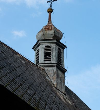 Zdjęcie nr 38: Drewniany kościół pw. św. Mikołaja w Polance jest budowlą orientowaną. Do prostokątnej nawy przylega węższe, wydłużone, trójbocznie zamknięte prezbiterium z piętrową zakrystią na osi o poligonalnym zamknięciu. Do zakrystii przylega od południa kruchta. Fragment północnej ściany prezbiterium jest murowany. Od zachodu do nawy dobudowano czworoboczną wieżę poprzedzoną przedsionkiem, który również dostawiono do nawy od południa. Prezbiterium i nawę wzniesiono na zrąb, natomiast wieżę w konstrukcji słupowej. Wieża na rzucie kwadratu posiada dwie kondygnacje. Dolna jest tej samej szerokości co nawa, górna natomiast znacznie węższa. Jej masyw podzielono smukłymi pilastrami i lizenami, zaś poniżej profilowanego gzymsu koronującego umieszczono wyrzynaną w desce koronkę. Kondygnacje oddzielono daszkiem gontowym zlewającym się po bokach z dachem kościoła. Wieżę nakryto kopulastym hełmem blaszanym, zwieńczonym blaszanym obeliskiem z krzyżem. Prezbiterium i nawę nakryto eternitowym dachem siodłowym podkreślonym profilowanym gzymsem. Nad nawą w części wschodniej zainstalowano wieżyczkę na sygnaturkę w formie wielobocznego graniastosłupa przykrytego cebulastą banią z krzyżem. Dokoła kościoła założono daszek gontowy chroniący podwaliny. Pod kościołem urządzono kryptę grzebalną. Wnętrze kościoła artykułowano za pomocą pilastrów i gzymsu. Całość nakryto stropem z fasetą. Otwór tęczowy uzyskał kształt trójlistnego, ściętego łuku, wspartego na filarkach ustawionych na profilowanej belce zawieszonej na kroksztynach. W części zachodniej nawy urządzono chór muzyczny, wsparty na dwóch kolumnach jońskich z przedpiersiem rozczłonkowanym balasami. We wnętrzu ustawiono ołtarz główny i dwa ołtarze boczne oraz ambonę, a na chórze muzycznym zainstalowano prospekt organowy.