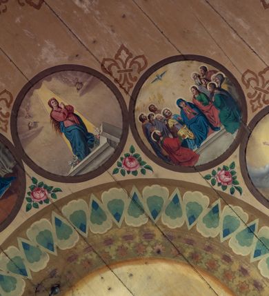 Zdjęcie nr 8: Polichromia malarska we wnętrzu drewnianego kościoła parafialnego w Polance Wielkiej zachowała się w prezbiterium, nawie oraz w przedsionku urządzonym w przyziemiu wieży. W prezbiterium i nawie zastosowano podział ramowy uwzględniający drewniane pilastry artykułujące ściany, gzyms oraz fasetę. Na ścianach pomiędzy pilastrami wprowadzono czworoboczne panneau o narożach utworzonych w stylizowanych formach nawiązujących do motywów roślinno-kwiatowych. Fasetę udekorowano rytmicznie rozłożonym ornamentem z motywów kwiatowych w formie dekoracyjnego fryzu, korespondującego z ornamentalną bordiurą poprowadzoną wzdłuż krawędzi płaskiego stropu. Na stropie w prezbiterium wyobrażono Trójcę Świętą, natomiast w nawie Matkę Boską Różańcową otoczoną przez tajemnice różańcowe w medalionach. Trójcę Świętą wyobrażono na obłokach na niebieskim tle usianym złotymi gwiazdkami. Frontalnie ujęty Bóg Ojciec został ukazany jako siwobrody starzec o bujnych siwych włosach. W prawej ręce trzyma złote berło, lewą zaś wyciąga przed siebie. Bóg Ojciec stopy wspiera o niebieski glob wyłaniający się z obłoków poniżej. Jego twarz charakteryzuje jasna karnacja, szeroko otwarte oczy, wydatny nos i usta. Głowę otacza długa, siwa broda i podobne włosy. Obok Boga Ojca z lewej strony siedzi Chrystus, który obie nogi wspiera na globie. Zbawiciel prawą ręką podtrzymuje oparty o ramię drewniany krzyż, lewą zaś ma odsuniętą od siebie. Jezus został przedstawiony w trzech czwartych w prawo. Jest to dojrzały mężczyzna o pociągłej twarzy okolonej brązowymi, długimi włosami spływającymi na ramiona oraz brodą. Ma jasną karnację, prosty nos i wydatne usta. Nagi tors okrywa bladoszkarłatny płaszcz odsłaniający prawą nogę. Na dłoniach i stopach widoczne są rany po gwoździach. Głowę Jezusa okala świetlisty nimb. Powyżej obu postaci na tle rozjaśnionego nieba unosi się gołębica Ducha Świętego w promienistym otoku. Polichromia stropu w nawie została zakomponowana w oparciu o zmniejszające się koncentryczne okręgi wpisane w dekoracjne panneau o narożach utworzonych ze stylizowanych form nawiązujących do motywów roślinno-kwiatowych. W środkowym okręgu ukazano zasiadającą na obłokach Matkę Boską z Dzieciątkiem otoczoną okrągłym obramieniem utworzonym z wielobarwnego ornamentu z motywem naprzemiennie ułożonych lancetowatych liści-łusek. Madonna została przedstawiona frontalnie, z prawą ręką przyłożoną do piersi, lewą zaś obejmuje Dzieciątko Jezus siedzące na globie ułożonym na kolanach matki podtrzymywanym przez anioła. Maryja ma pociągłą twarz o wydatnym nosie i wargach. Jej spojrzenie półprzymkniętych oczu skierowane jest pokornie ku dołowi. Głowę Marii otaczają, brązowe, falujące włosy spływające na ramiona. Madonna ubrana jest w czerwoną suknię przewiązaną złocistą szarfą w pasie i niebieski płaszcz lamowany złotą taśmą, spięty pod szyją z lewą połą osłaniającą jej kolana. Lewą stopę Matka Boska wspiera o wystający spod płaszcza poniżej złoty półksiężyc. Siedzące na globie Dzieciątko ujęte zostało w trzech czwartych w lewo. Mały Jezus prawą ręką nakłada matce złotą koronę, w lewej zaś trzyma lilię. Zbawiciel ma owalną twarz o jasnej karnacjim i rumianych policzkach z drobnym nosem i ustami. Jego głowę okalają jasne loki. Ubrany jest w jasną przepaskę przerzuconą przez prawe ramię oraz biodra. Głowy obu postaci otaczają świetliste promienie. Z prawej strony Marii stoi ujęty w trzech czwarty w prawo anioł, z twarzą zwróconą w stronę widza, podtrzymujący oburącz niebieski glob, na którym siedzi Jezus. Uskrzydlony anioł o jasnobrązowych włosach ubrany jest w zieloną tunikę przewiązaną w pasie. Za Madonną z lewej strony widoczny jest asystujący drugi anioł w cynobrowej tunice i jasnych włosach spływających na ramiona. Pod półksiężycem na tle obłoków widoczne są trzy uskrzydlone główki anielskie. Wokół Matki Boskiej rozmieszczono owalne medaliony z blachy miedzianej malowane w piętnaście tajemnic Różańca świętego. Ich narracja rozpoczyna się nad głową Madonny. Każda ze scen oparta jest o kilkuosobową kompozycję. Idąc w lewo namalowano: Zwiastowanie Marii, Nawiedzenie św. Elżbiety, Boże Narodzenie, Ofiarowanie w świątyni, Znalezienie w świątyni, Modlitwa w Ogrójcu, Biczowanie, Cierniem ukoronowanie, Niesienie krzyża, Ukrzyżowanie, Zmartwychwstanie, Wniebowstąpienie, Zesłanie Ducha Świętego, Wniebowzięcie Marii, Ukoronowanie Marii w niebie. Pomiędzy medalionami namalowano czerwone róże. Całoś obramienia ornamentalny okrąg. Dekorację w przedsionku utworzono za pomocą iluzjonistycznie malowanych cynobrowych kolumn o korynckich kapitelach ustawionych na wysokich postumentach, podtrzymujących belkowanie. Pomiędzy kolumnami ściany są gładkie, bladoniebieskie. Strop ozdobiono obramieniem w formie czworobocznego panneau o narożach utworzonych ze stylizowanych form nawiązujących do motywów roślinno-kwiatowych. 