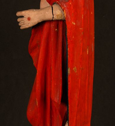 Zdjęcie nr 14: Rzeźba pełnoplastyczna, z tyłu opracowana. Chrystus, ukazany w całej postaci, frontalnie, stoi i na niewysokiej wypukłej podstawie, w kontrapoście, z prawą nogą ugiętą w kolanie. Ręce ugięte w łokciach, prawą błogosławi, lewą podtrzymuje połę płaszcza i zapewne niezachowane drzewce chorągwi. Głowa wydłużona, z wysokim czołem okolona krótkim zarostem i długimi ciemnymi włosami spływającymi w puklach na barki i plecy. Twarz pociągła, z wąskim nosem i małymi ustami. Ciało nagie, o jasnej karnacji, z ranami na dłoniach, stopach i w prawym boku, okryte perizonium oraz długim, sięgającym do ziemi, czerwonym płaszczem z niebieską podszewką, narzuconym na ramiona, spiętym pod szyją i z prawą połą przerzuconą przez przód postaci; pod prawą ręką okazały fałd muszlowy. 