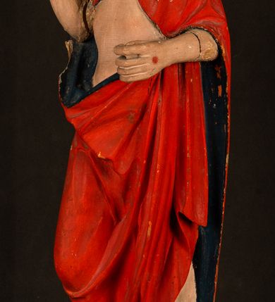 Zdjęcie nr 12: Rzeźba pełnoplastyczna, z tyłu opracowana. Chrystus, ukazany w całej postaci, frontalnie, stoi i na niewysokiej wypukłej podstawie, w kontrapoście, z prawą nogą ugiętą w kolanie. Ręce ugięte w łokciach, prawą błogosławi, lewą podtrzymuje połę płaszcza i zapewne niezachowane drzewce chorągwi. Głowa wydłużona, z wysokim czołem okolona krótkim zarostem i długimi ciemnymi włosami spływającymi w puklach na barki i plecy. Twarz pociągła, z wąskim nosem i małymi ustami. Ciało nagie, o jasnej karnacji, z ranami na dłoniach, stopach i w prawym boku, okryte perizonium oraz długim, sięgającym do ziemi, czerwonym płaszczem z niebieską podszewką, narzuconym na ramiona, spiętym pod szyją i z prawą połą przerzuconą przez przód postaci; pod prawą ręką okazały fałd muszlowy. 