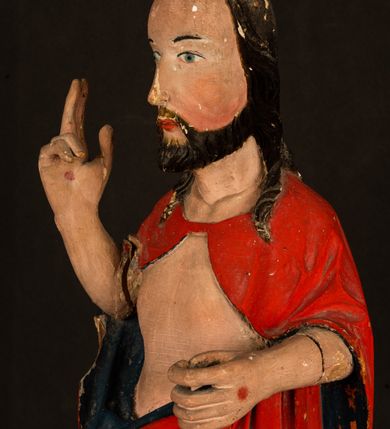Zdjęcie nr 7: Rzeźba pełnoplastyczna, z tyłu opracowana. Chrystus, ukazany w całej postaci, frontalnie, stoi i na niewysokiej wypukłej podstawie, w kontrapoście, z prawą nogą ugiętą w kolanie. Ręce ugięte w łokciach, prawą błogosławi, lewą podtrzymuje połę płaszcza i zapewne niezachowane drzewce chorągwi. Głowa wydłużona, z wysokim czołem okolona krótkim zarostem i długimi ciemnymi włosami spływającymi w puklach na barki i plecy. Twarz pociągła, z wąskim nosem i małymi ustami. Ciało nagie, o jasnej karnacji, z ranami na dłoniach, stopach i w prawym boku, okryte perizonium oraz długim, sięgającym do ziemi, czerwonym płaszczem z niebieską podszewką, narzuconym na ramiona, spiętym pod szyją i z prawą połą przerzuconą przez przód postaci; pod prawą ręką okazały fałd muszlowy. 