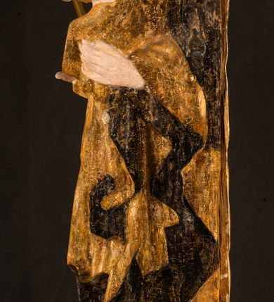 Zdjęcie nr 23: Rzeźba drążona ustawiona na niewielkim, wielobocznym postumencie. Maria ukazana w pozycji stojącej, frontalnie z ciałem ułożonym z lekkim kontrapoście. Lewą ręką podtrzymuje Dzieciątko Jezus, w prawej trzyma złocone berło zwieńczone kwiatem. Matka Boska przedstawiona jako młoda kobieta o podłużnej twarzy z wysokim czołem, migdałowatymi oczami oraz krótkim nosem i małymi ustami ułożonymi w delikatny uśmiech. Karnacja jasna, policzki wyraźnie zaróżowione. Długie, ciemne i falowane włosy rozdzielone przedziałkiem opadają na ramiona postaci. Na głowie Marii ciemna chusta oraz złocona korona (pozostałość korony?) lub diadem. Madonna jest ubrana w ciemną suknię z długimi rękawami dekorowaną motywem roślinnym oraz złocony płaszcz spięty pod szyją klamrą w kształcie kwiatu. Dzieciątko Jezus przedstawione w pozycji siedzącej z głową mocno pochyloną w bok i skrzyżowanymi stópkami. W ręku trzyma otwartą księgę. Twarz owalna, pulchna, ciemne oczy skierowane w lewo, usta w wyraźnym uśmiechu. Włosy, krótkie, falowane w kolorze brązowym. Dzieciątko jest ubrane w złoconą tkaninę udrapowaną wokół bioder. Figura polichromowana i częściowo złocona. Na odwrociu napis „Powtóre odzłocona / zarządem x(iędza) / Pawła Pomian Izdeb / skiego przez / Karol(a) Rośka / R(oku) P(ańskiego) 1853”.