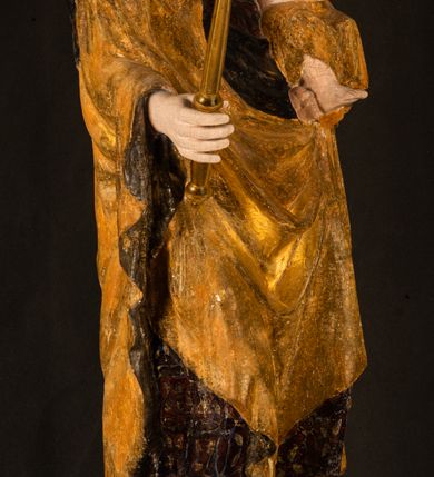 Zdjęcie nr 2: Rzeźba drążona ustawiona na niewielkim, wielobocznym postumencie. Maria ukazana w pozycji stojącej, frontalnie z ciałem ułożonym z lekkim kontrapoście. Lewą ręką podtrzymuje Dzieciątko Jezus, w prawej trzyma złocone berło zwieńczone kwiatem. Matka Boska przedstawiona jako młoda kobieta o podłużnej twarzy z wysokim czołem, migdałowatymi oczami oraz krótkim nosem i małymi ustami ułożonymi w delikatny uśmiech. Karnacja jasna, policzki wyraźnie zaróżowione. Długie, ciemne i falowane włosy rozdzielone przedziałkiem opadają na ramiona postaci. Na głowie Marii ciemna chusta oraz złocona korona (pozostałość korony?) lub diadem. Madonna jest ubrana w ciemną suknię z długimi rękawami dekorowaną motywem roślinnym oraz złocony płaszcz spięty pod szyją klamrą w kształcie kwiatu. Dzieciątko Jezus przedstawione w pozycji siedzącej z głową mocno pochyloną w bok i skrzyżowanymi stópkami. W ręku trzyma otwartą księgę. Twarz owalna, pulchna, ciemne oczy skierowane w lewo, usta w wyraźnym uśmiechu. Włosy, krótkie, falowane w kolorze brązowym. Dzieciątko jest ubrane w złoconą tkaninę udrapowaną wokół bioder. Figura polichromowana i częściowo złocona. Na odwrociu napis „Powtóre odzłocona / zarządem x(iędza) / Pawła Pomian Izdeb / skiego przez / Karol(a) Rośka / R(oku) P(ańskiego) 1853”.