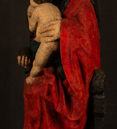 Zdjęcie nr 11: Rzeźba drążona przedstawiająca siedzącą św. Annę w towarzystwie klęczącej Marii oraz Dzieciątka Jezus. Anna ukazana frontalnie, z głową pochyloną nieznacznie w dół, obejmująca rękoma przedstawioną z prawej strony Marię oraz znajdujące się po lewej stronie Dzieciątko Jezus. Twarz świętej owalna o spokojnym wyrazie, z oczami skierowanymi w dół. Nos długi, prosty, na policzkach zaznaczony delikatny rumieniec. Anna ubrana jest w ciemnozieloną suknię przepasaną w talii, ciemnogranatową chustę zarzuconą na głowę, pod którą znajduje się biała podwika. Na ramiona i kolana postaci narzucony jest obszerny, czerwony płaszcz spod, którego widoczny jest ostro zakończony czubek brązowego buta św. Anny. Maria znajdująca się z lewej strony kompozycji została  przedstawiona jako młoda kobieta, klęcząca u stóp swojej matki i zwracająca się w kierunku siedzącego na kolanach Anny Dzieciątka Jezus. Owalną twarz Marii charakteryzuje wysokie czoło i cienkie, łukowato wygięte brwi. Długie, ciemne i lekko falowane włosy opadają na ramiona i plecy postaci. Maria swoją prawą rękę wspiera na kolanach Anny, lewą wyciąga przed siebie, podając Dzieciątku jabłko królewskie. Ubrana jest w ciemnogranatową suknię z długimi rękawami, spod której widoczne są bose stopy. Chrystus został ukazany jako nagi, ciemnowłosy chłopiec  o okrągłej twarzy z rumieńcem siedzący na kolanach św. Anny i wyciągający obie ręce w kierunku Marii. Rzeźba w pełni polichromowana.