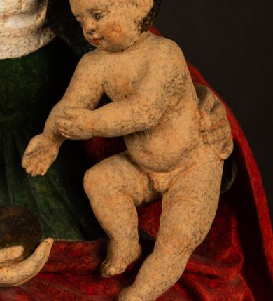 Zdjęcie nr 4: Rzeźba drążona przedstawiająca siedzącą św. Annę w towarzystwie klęczącej Marii oraz Dzieciątka Jezus. Anna ukazana frontalnie, z głową pochyloną nieznacznie w dół, obejmująca rękoma przedstawioną z prawej strony Marię oraz znajdujące się po lewej stronie Dzieciątko Jezus. Twarz świętej owalna o spokojnym wyrazie, z oczami skierowanymi w dół. Nos długi, prosty, na policzkach zaznaczony delikatny rumieniec. Anna ubrana jest w ciemnozieloną suknię przepasaną w talii, ciemnogranatową chustę zarzuconą na głowę, pod którą znajduje się biała podwika. Na ramiona i kolana postaci narzucony jest obszerny, czerwony płaszcz spod, którego widoczny jest ostro zakończony czubek brązowego buta św. Anny. Maria znajdująca się z lewej strony kompozycji została  przedstawiona jako młoda kobieta, klęcząca u stóp swojej matki i zwracająca się w kierunku siedzącego na kolanach Anny Dzieciątka Jezus. Owalną twarz Marii charakteryzuje wysokie czoło i cienkie, łukowato wygięte brwi. Długie, ciemne i lekko falowane włosy opadają na ramiona i plecy postaci. Maria swoją prawą rękę wspiera na kolanach Anny, lewą wyciąga przed siebie, podając Dzieciątku jabłko królewskie. Ubrana jest w ciemnogranatową suknię z długimi rękawami, spod której widoczne są bose stopy. Chrystus został ukazany jako nagi, ciemnowłosy chłopiec  o okrągłej twarzy z rumieńcem siedzący na kolanach św. Anny i wyciągający obie ręce w kierunku Marii. Rzeźba w pełni polichromowana.