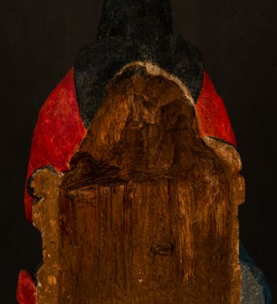 Zdjęcie nr 14: Rzeźba drążona przedstawiająca siedzącą św. Annę w towarzystwie klęczącej Marii oraz Dzieciątka Jezus. Anna ukazana frontalnie, z głową pochyloną nieznacznie w dół, obejmująca rękoma przedstawioną z prawej strony Marię oraz znajdujące się po lewej stronie Dzieciątko Jezus. Twarz świętej owalna o spokojnym wyrazie, z oczami skierowanymi w dół. Nos długi, prosty, na policzkach zaznaczony delikatny rumieniec. Anna ubrana jest w ciemnozieloną suknię przepasaną w talii, ciemnogranatową chustę zarzuconą na głowę, pod którą znajduje się biała podwika. Na ramiona i kolana postaci narzucony jest obszerny, czerwony płaszcz spod, którego widoczny jest ostro zakończony czubek brązowego buta św. Anny. Maria znajdująca się z lewej strony kompozycji została  przedstawiona jako młoda kobieta, klęcząca u stóp swojej matki i zwracająca się w kierunku siedzącego na kolanach Anny Dzieciątka Jezus. Owalną twarz Marii charakteryzuje wysokie czoło i cienkie, łukowato wygięte brwi. Długie, ciemne i lekko falowane włosy opadają na ramiona i plecy postaci. Maria swoją prawą rękę wspiera na kolanach Anny, lewą wyciąga przed siebie, podając Dzieciątku jabłko królewskie. Ubrana jest w ciemnogranatową suknię z długimi rękawami, spod której widoczne są bose stopy. Chrystus został ukazany jako nagi, ciemnowłosy chłopiec  o okrągłej twarzy z rumieńcem siedzący na kolanach św. Anny i wyciągający obie ręce w kierunku Marii. Rzeźba w pełni polichromowana.