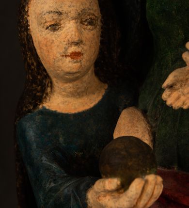 Zdjęcie nr 9: Rzeźba drążona przedstawiająca siedzącą św. Annę w towarzystwie klęczącej Marii oraz Dzieciątka Jezus. Anna ukazana frontalnie, z głową pochyloną nieznacznie w dół, obejmująca rękoma przedstawioną z prawej strony Marię oraz znajdujące się po lewej stronie Dzieciątko Jezus. Twarz świętej owalna o spokojnym wyrazie, z oczami skierowanymi w dół. Nos długi, prosty, na policzkach zaznaczony delikatny rumieniec. Anna ubrana jest w ciemnozieloną suknię przepasaną w talii, ciemnogranatową chustę zarzuconą na głowę, pod którą znajduje się biała podwika. Na ramiona i kolana postaci narzucony jest obszerny, czerwony płaszcz spod, którego widoczny jest ostro zakończony czubek brązowego buta św. Anny. Maria znajdująca się z lewej strony kompozycji została  przedstawiona jako młoda kobieta, klęcząca u stóp swojej matki i zwracająca się w kierunku siedzącego na kolanach Anny Dzieciątka Jezus. Owalną twarz Marii charakteryzuje wysokie czoło i cienkie, łukowato wygięte brwi. Długie, ciemne i lekko falowane włosy opadają na ramiona i plecy postaci. Maria swoją prawą rękę wspiera na kolanach Anny, lewą wyciąga przed siebie, podając Dzieciątku jabłko królewskie. Ubrana jest w ciemnogranatową suknię z długimi rękawami, spod której widoczne są bose stopy. Chrystus został ukazany jako nagi, ciemnowłosy chłopiec  o okrągłej twarzy z rumieńcem siedzący na kolanach św. Anny i wyciągający obie ręce w kierunku Marii. Rzeźba w pełni polichromowana.