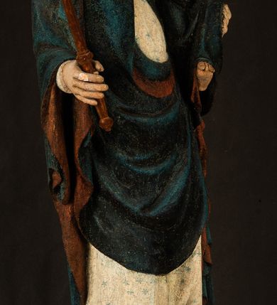 Zdjęcie nr 13: Rzeźba drążona, ukazująca Matkę Boską z Dzieciątkiem. Maria ustawiona frontalnie, w delikatnym kontrapoście, na lewym ręku trzyma Dzieciątko, w prawym dzierży berło. Twarz okrągła z wysokim czołem, drobnymi ustami i małymi oczami o delikatnie zarysowanych łukach brwiowych. Włosy jasne, ułożone w skręcone pukle spływające na plecy. Maria ubrana jest w białą suknię zdobioną drobnymi, niebieskimi gwiazdkami, ciemnobłękitny płaszcz z bordową podszewką spięty na piersi oraz spiczaste, brązowe buty. Na głowie ma założony ciemnoniebieski welon z bordową podszewką, spływający na ramiona i piersi oraz brązową podstawę do niezachowanej korony. Draperia szat miękka o wyraźnie zaznaczonych, licznych fałdach misowych i kaskadowych. Dzieciątko ukazane w pozycji siedzącej, zwrócone w prawo. W lewej dłoni trzyma jabłko królewskie, a prawą wyprostowaną podnosi na wysokość tułowia. Twarz pełna o dziecięcych rysach z małymi ustami, okolona krótkimi i kędzierzawymi włosami. Polichromia w odsłoniętych partiach ciała naturalistyczna, berło polichromowane na brązowo.