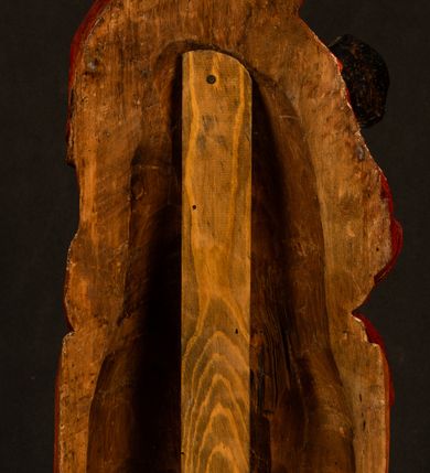 Zdjęcie nr 6: Rzeźba drążona, w pełni polichromowana. Pełnopostaciowe przedstawienie Marii karmiącej Dzieciątko Jezus. Matka Boska ukazana frontalnie, w pozycji siedzącej, trzyma na kolanach małego Jezusa, którego karmi piersią. Prawą ręką podtrzymuje Dzieciątko, lewą podaje mu pierś. Przedstawiona jako młoda kobieta o szerokiej, owalnej twarzy o wysokim czole i długich, ciemnych włosach. Oczy migdałowate, wpatrzone przed siebie. Cieńkie, łukowate brwi, niewielkie usta. Na głowie charakterystyczne podwyższenie – zapewne ślad po mocowaniu korony. Maria ubrana jest w ciemnogranatową, obcisłą suknię z długimi rękawami oraz czerwony płaszcz. Poła płaszcza okrywa również biodra Dzieciątka. Spod fałdów szat widoczne są czarne trzewiki o spiczastych noskach. Dzieciątko ukazane w pozycji siedzącej z głową uniesioną do góry, wyciągniętymi do przodu nóżkami i lewą ręką trzymającą pierś Marii. Twarz pełna z szeroko otwartymi oczami wpatrzonymi w matkę i zaróżowionymi policzkami. Włosy, krótkie, ciemne.