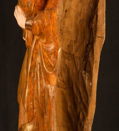 Zdjęcie nr 16: Rzeźba pełnoplastyczna, przyścienna, z tyłu wydrążona. Przedstawienie Matki Boskiej z Dzieciątkiem, ukazanej w całej postaci, frontalnie. Maria stoi w kontrapoście, esowato wygięta, z głową lekko przechyloną w lewo, podtrzymując Dzieciątko ręką wspartą na lewym biodrze. Twarz owalna, o subtelnych rysach, z wysokim czołem, regularnymi łukami brwiowymi i dużymi oczami, długim, wąskim nosem, małymi ustami i wydatnym podbródkiem. Ubrana w długą suknię i narzucony na ramiona płaszcz, przerzucony przez przód sylwetki i układający się poniżej piersi Marii sekwencją fałdów misowych i v-kształtnych. Na głowie źle zachowana chusta spływająca na ramiona. Dzieciątko siedzi na lewym przedramieniu Matki, ze skrzyżowanymi nóżkami, prawą dłonią dotykając piersi Marii, lewą trzyma glob. Twarz okrągła, o drobnych rysach, okolona krótkimi ciemnymi włosami. Jezus ubrany w długą sukienkę, spod której widać bose stopy.   