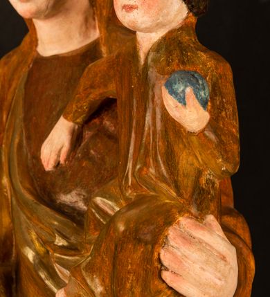 Zdjęcie nr 9: Rzeźba pełnoplastyczna, przyścienna, z tyłu wydrążona. Przedstawienie Matki Boskiej z Dzieciątkiem, ukazanej w całej postaci, frontalnie. Maria stoi w kontrapoście, esowato wygięta, z głową lekko przechyloną w lewo, podtrzymując Dzieciątko ręką wspartą na lewym biodrze. Twarz owalna, o subtelnych rysach, z wysokim czołem, regularnymi łukami brwiowymi i dużymi oczami, długim, wąskim nosem, małymi ustami i wydatnym podbródkiem. Ubrana w długą suknię i narzucony na ramiona płaszcz, przerzucony przez przód sylwetki i układający się poniżej piersi Marii sekwencją fałdów misowych i v-kształtnych. Na głowie źle zachowana chusta spływająca na ramiona. Dzieciątko siedzi na lewym przedramieniu Matki, ze skrzyżowanymi nóżkami, prawą dłonią dotykając piersi Marii, lewą trzyma glob. Twarz okrągła, o drobnych rysach, okolona krótkimi ciemnymi włosami. Jezus ubrany w długą sukienkę, spod której widać bose stopy.   